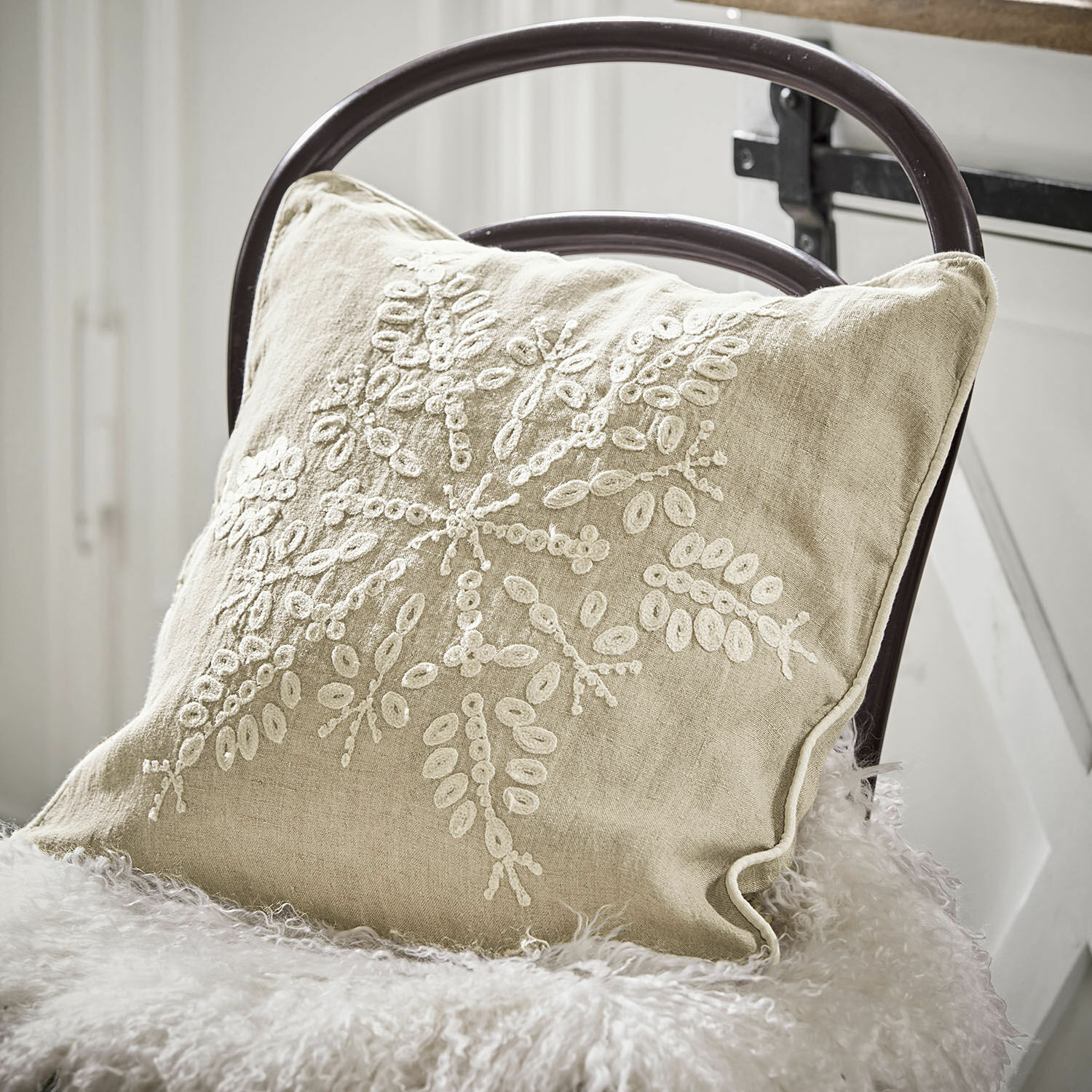 Kissenhülle Snowflake Beiges Leinenkissen mit weisser Stickerei auf Stuhl mit Fellüberwurf, Wohnaccessoire