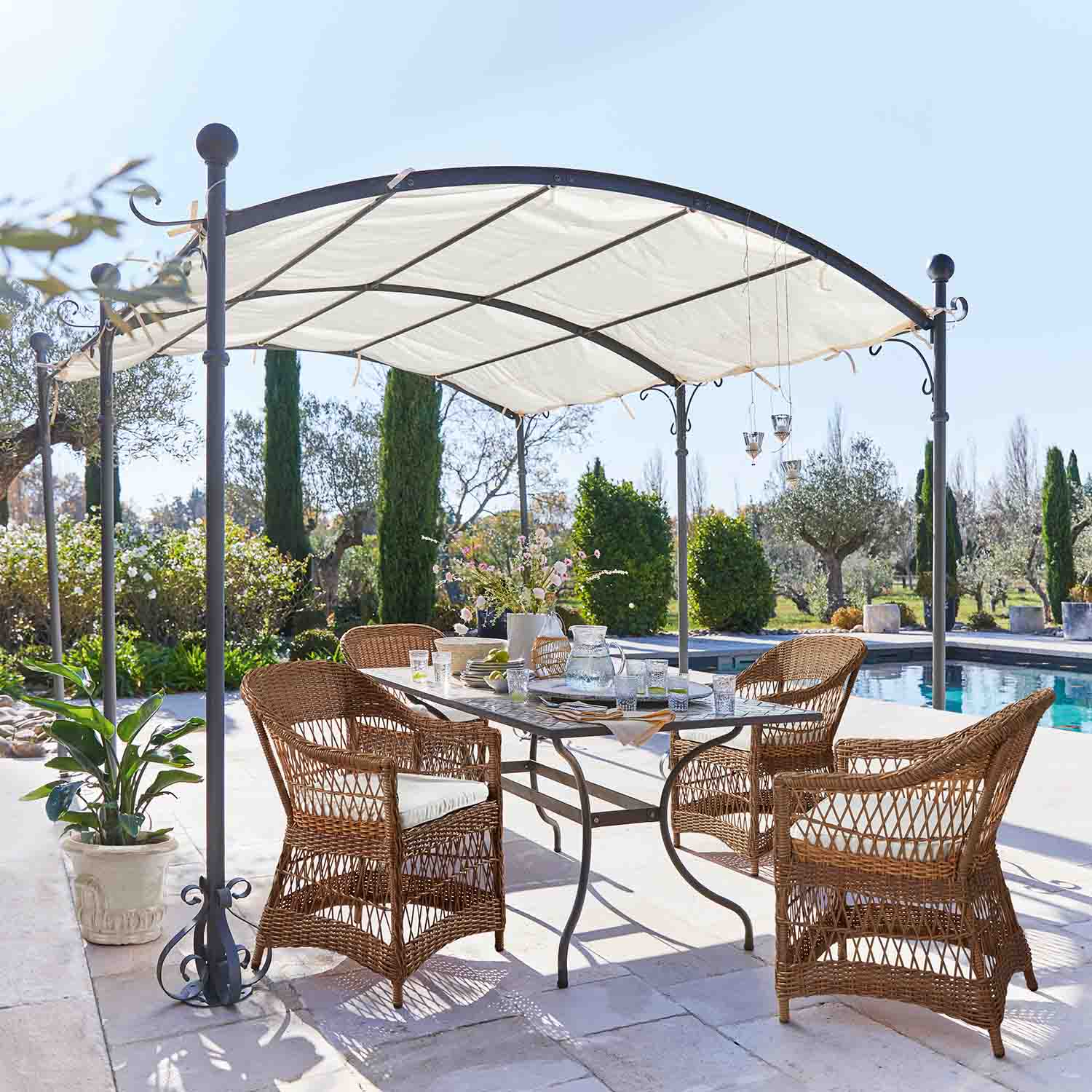 Braunes Rattan-Gartenmöbel-Set unter Metallpavillon am Pool auf der Terrasse