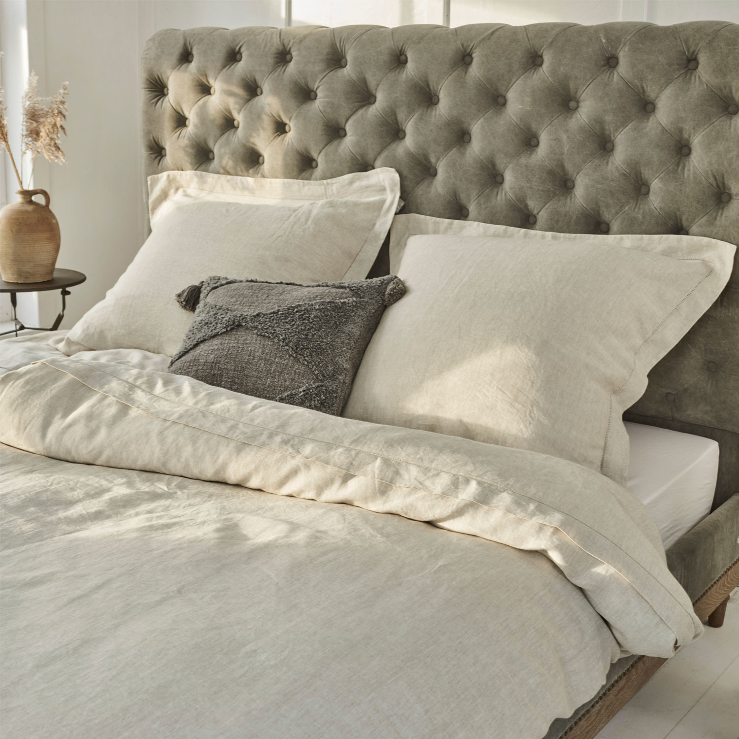 Bettwäsche Kilanema Beige Leinenbettwäsche auf Bett mit grauem, gestepptem Kopfteil, graues Zierkissen