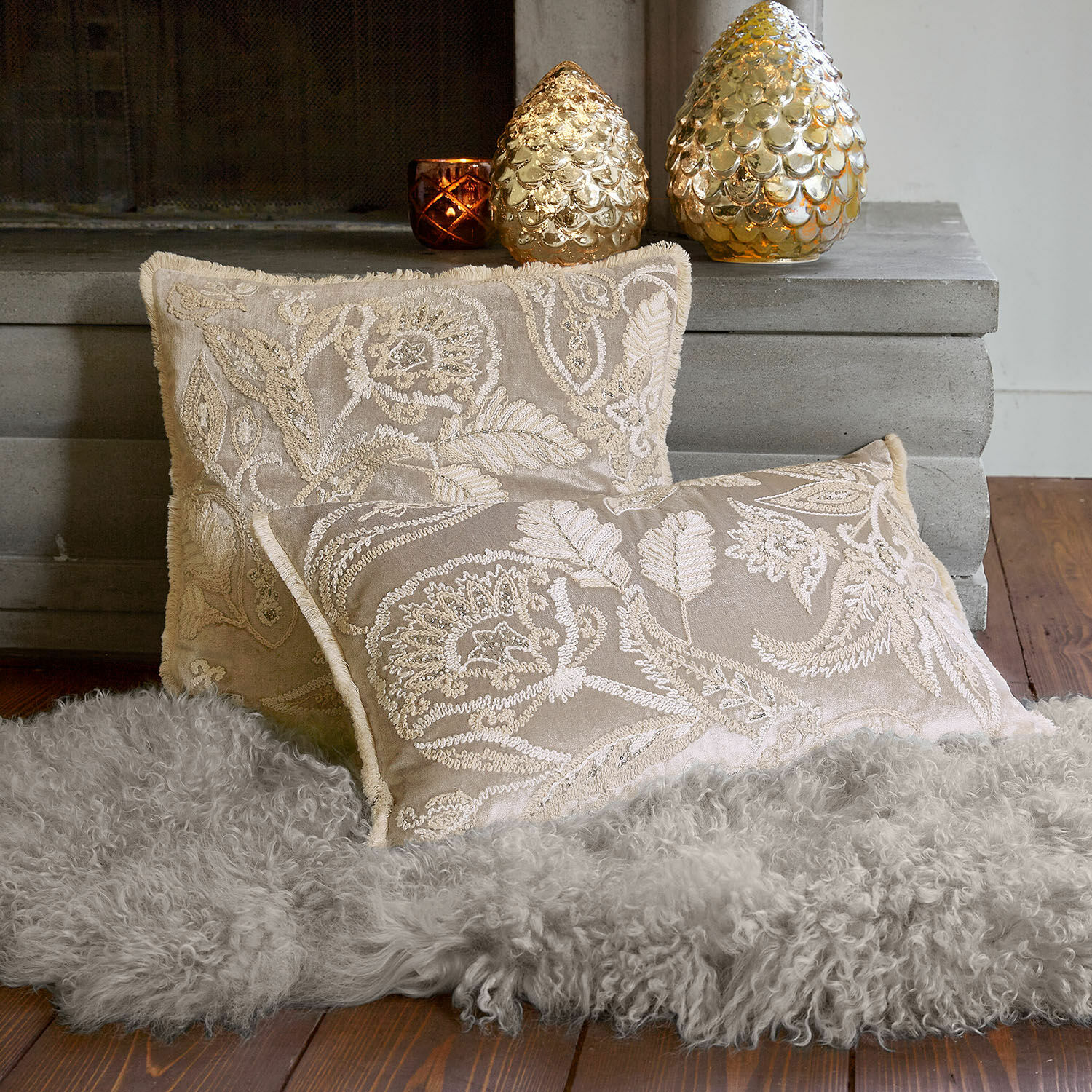 Kissenhülle 2er Set Oplevine Beige bestickte Dekokissen auf grauem Fellteppich vor dem Kamin, Wohntextilien für gemütliche Räume