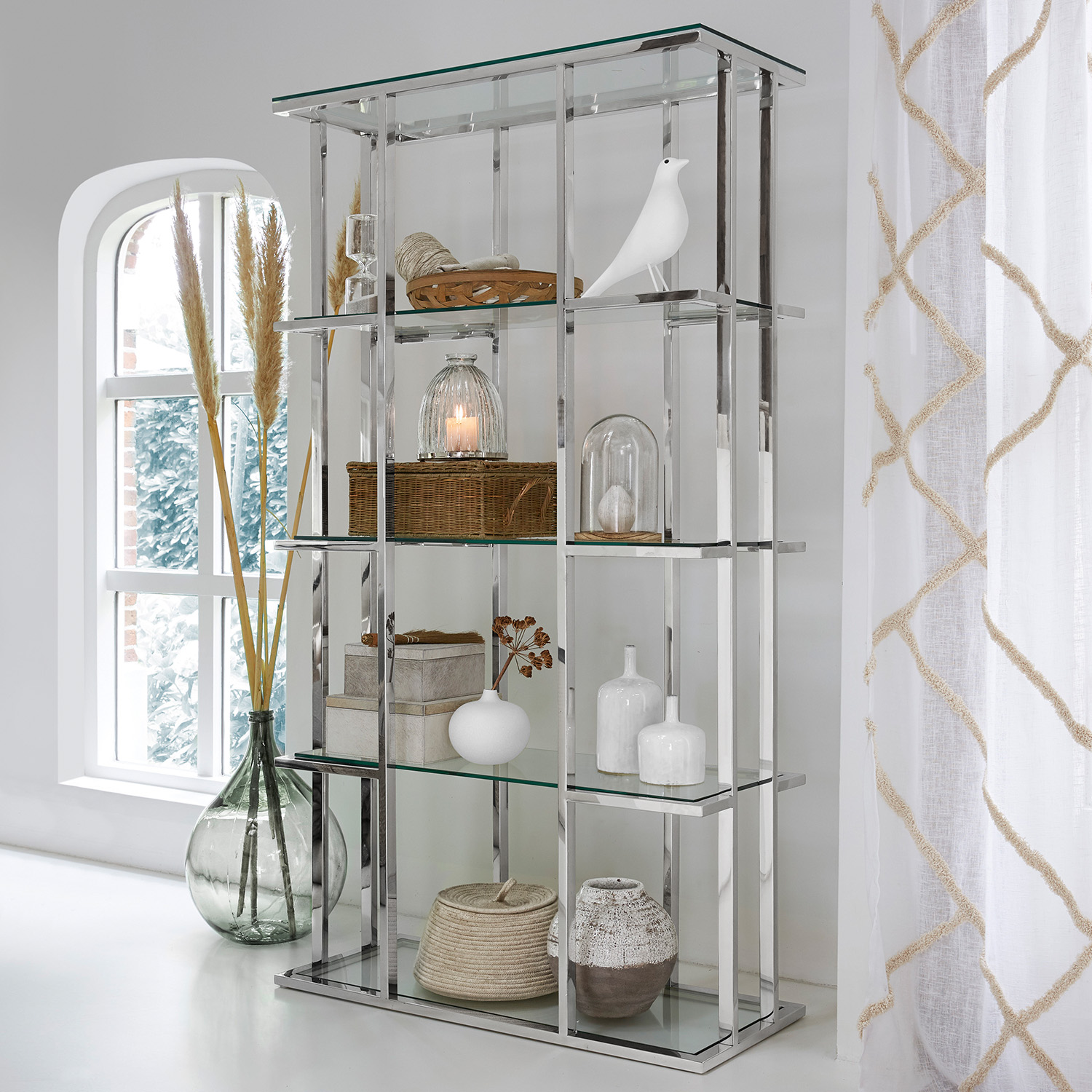 Moderne Glasvitrine mit silbernem Metallrahmen und dekorativen Wohnaccessoires