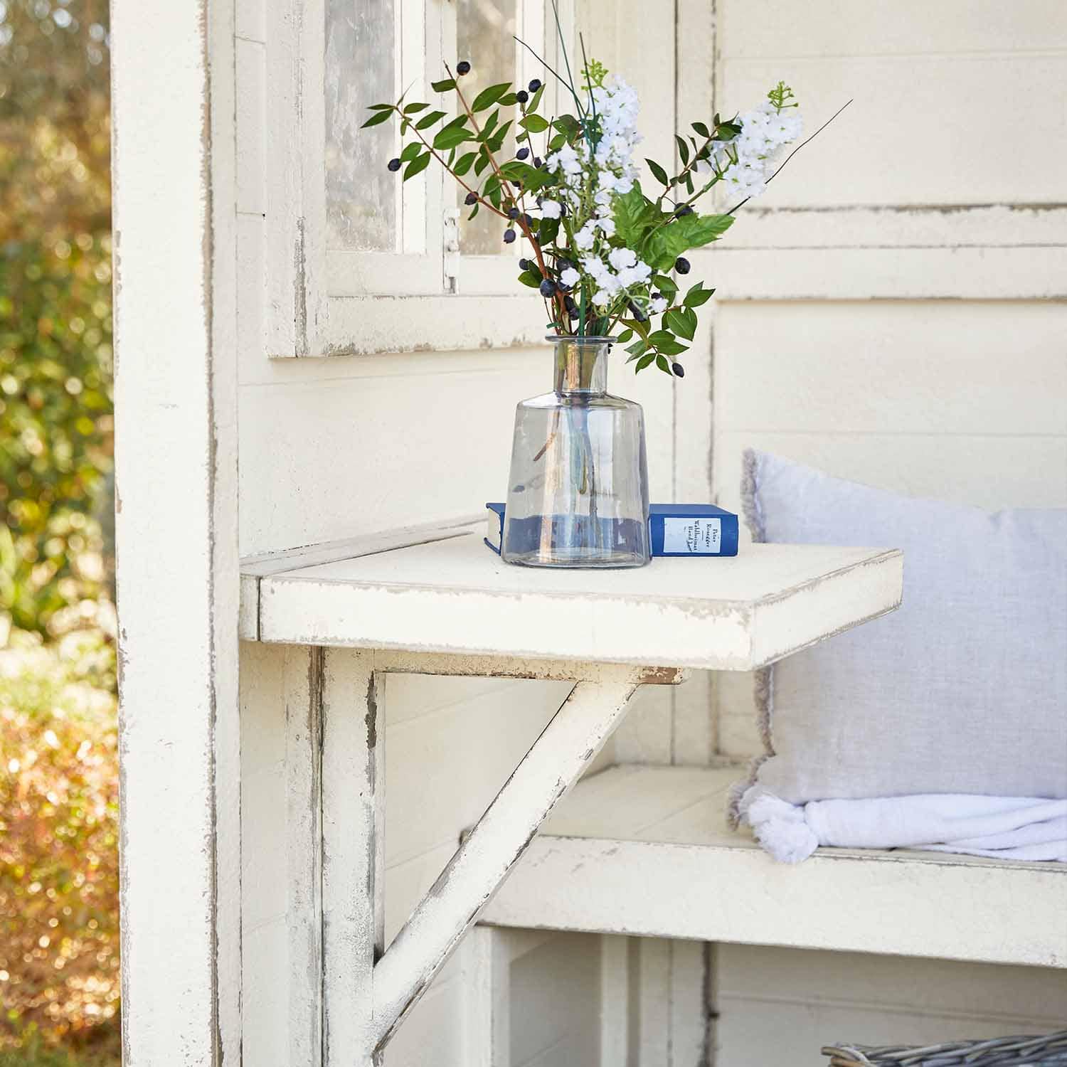 Weißer klappbarer Holztisch mit klarem Glasvase und Blumen, Gartendekoration