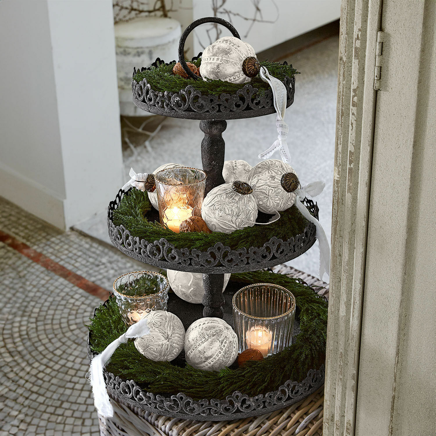 Etagere Garnette Dreistöckiges schwarzes Metall-Etagere mit weissen Dekokugeln und brennenden Kerzen