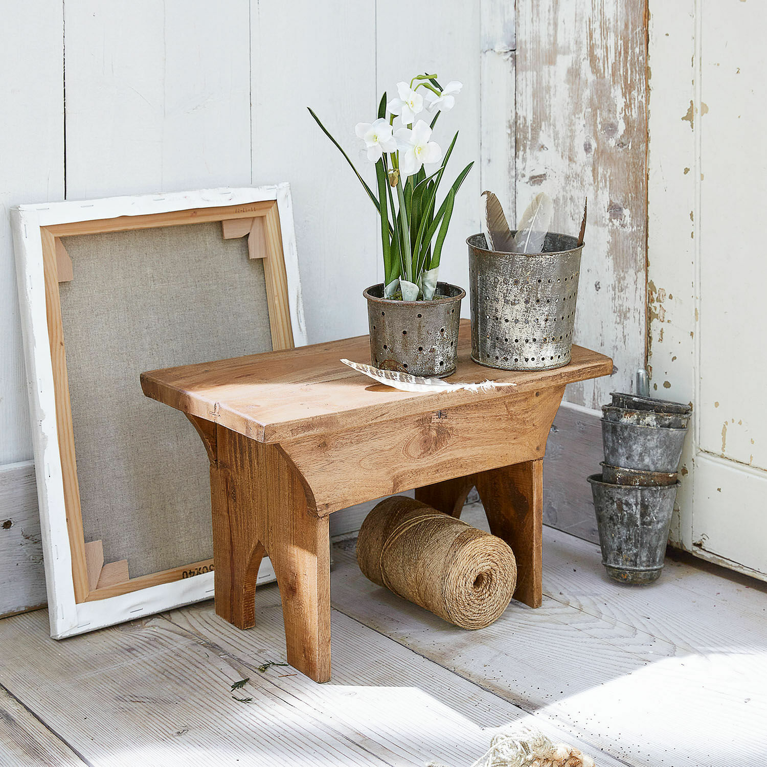 Hocker Hoboken Kleiner Holzschemel mit Metalltöpfen und weissen Blumen auf hellem Holzboden