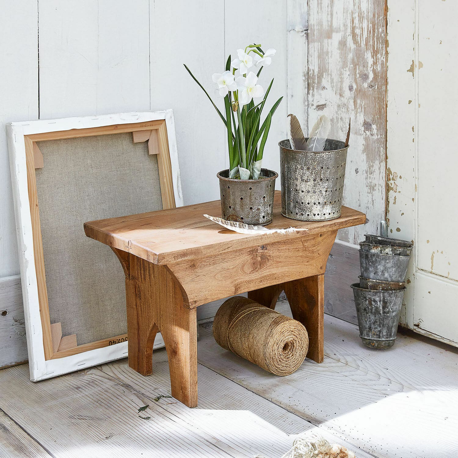 Hocker Hoboken Kleiner Holzschemel mit Metalltöpfen und weissen Blumen auf hellem Holzboden