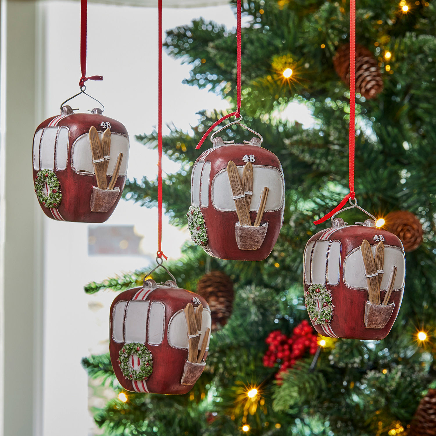 Anhänger 4er Set Barnes Rote Weihnachtsbaum-Anhänger in Form von Gondeln mit Skiern und Kranz am grünen Tannenbaum.