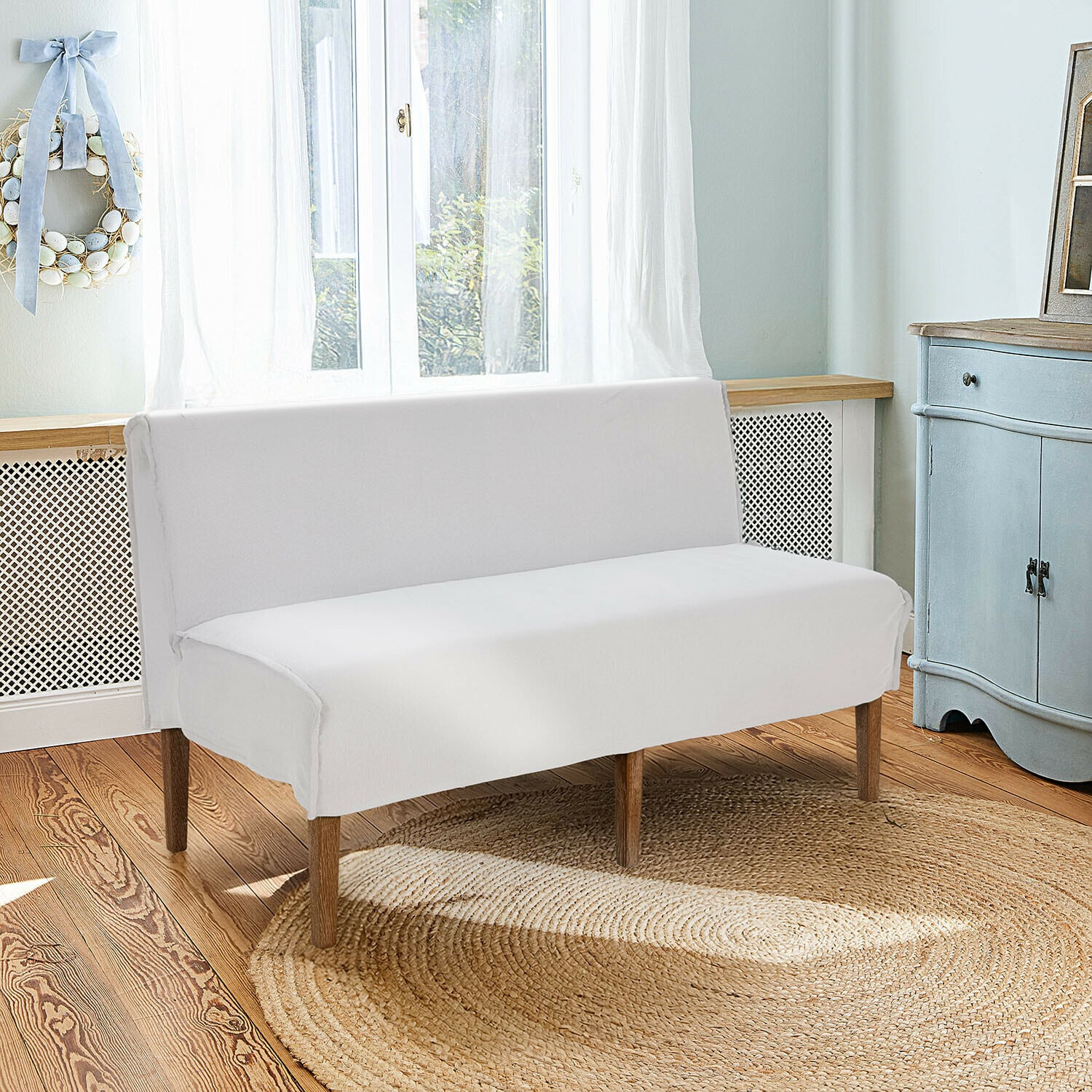 Küchensofa Vinterfjord Weisses Sofa mit Holzbeinen auf rundem Jute-Teppich in hellem, gemütlichem Raum