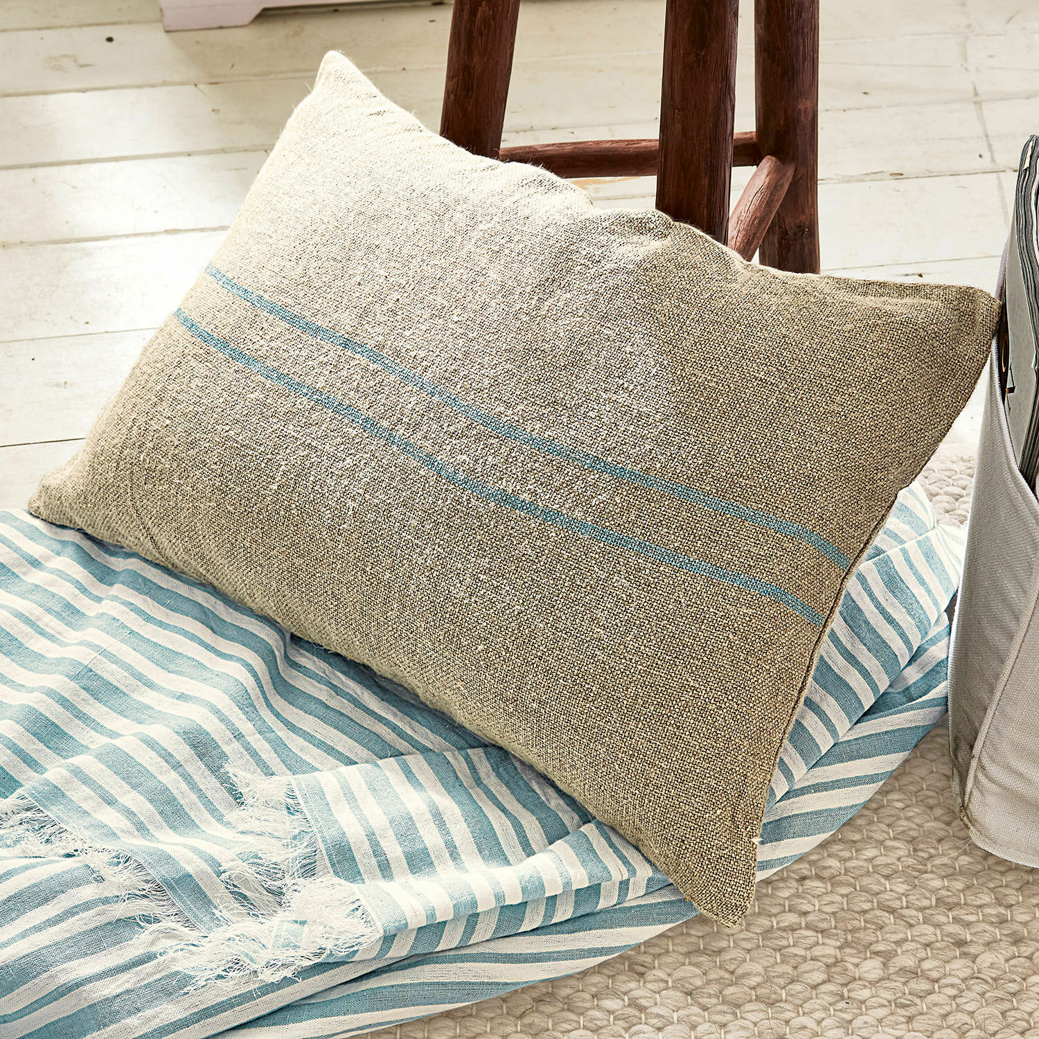 Kissenhülle Arrentès Beige Leinenkissen mit blauen Streifen auf blau-weiss gestreifter Decke, gemütliche Wohnaccessoires