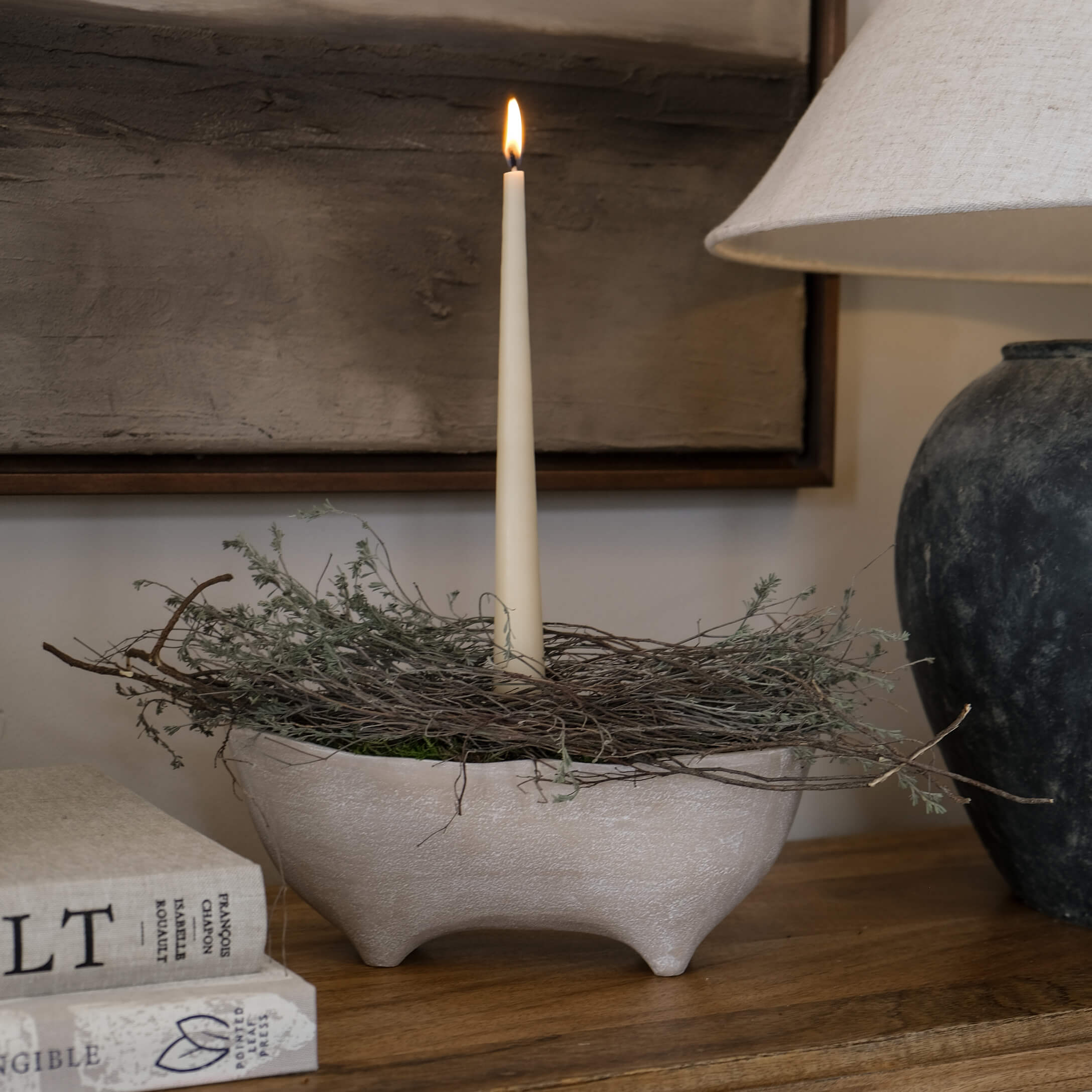 Beige Keramikschale mit drei Füssen, Zweig-Dekoration und einer weissen Stabkerze