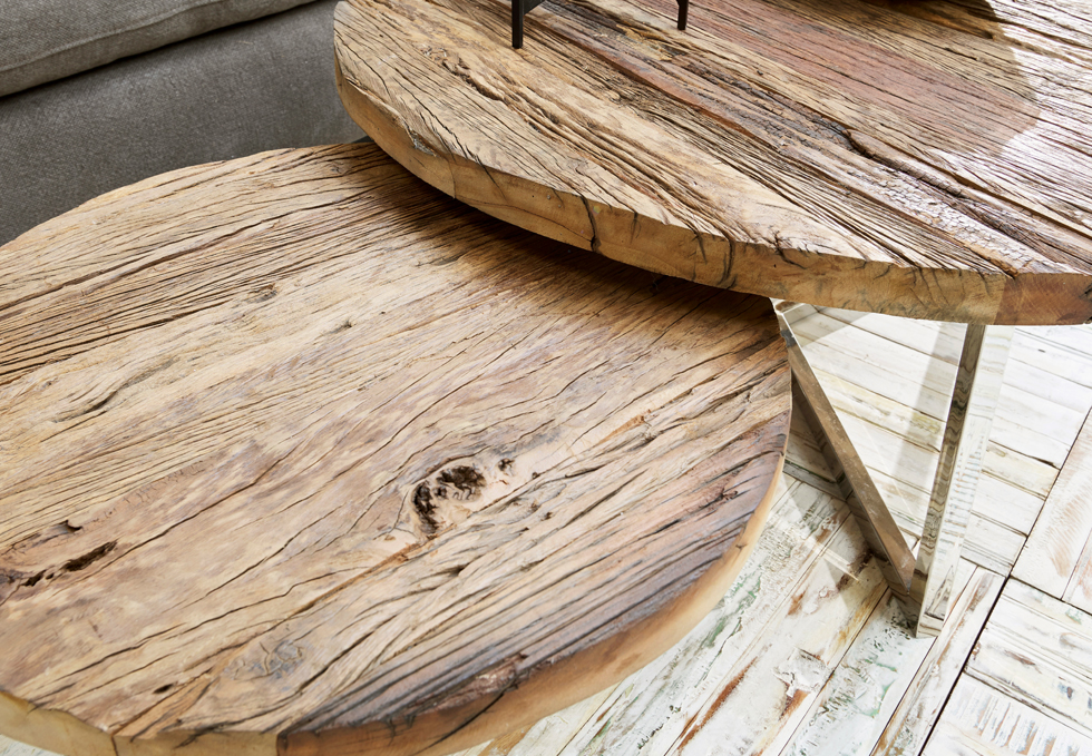 Zwei runde Tische aus naturbelassenem Holz mit sichtbarer Maserung und Metallbeinen im Industriestil.