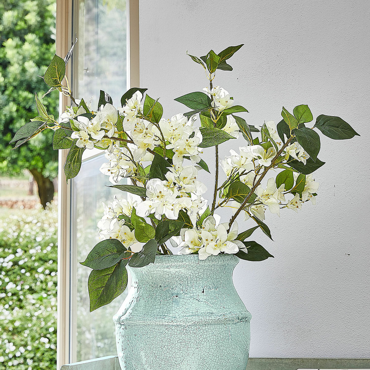 Deko-Blume 6er Set Nireval Weisse Blüten in grüner Keramikvase mit Risseffekt vor Fenster und weisser Wand