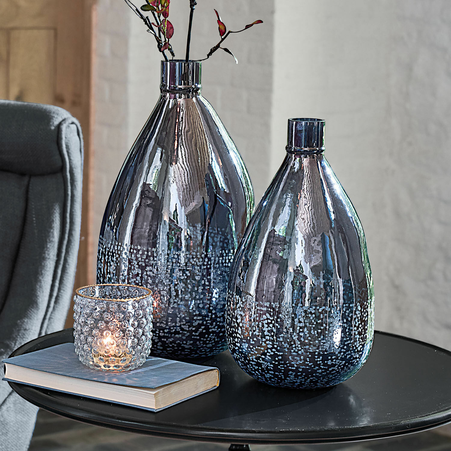 Vase 2er Set Qilevon Zwei dekorative Rauchglasvasen mit Blasenmuster auf schwarzem Tisch mit Buch und Kerzenhalter