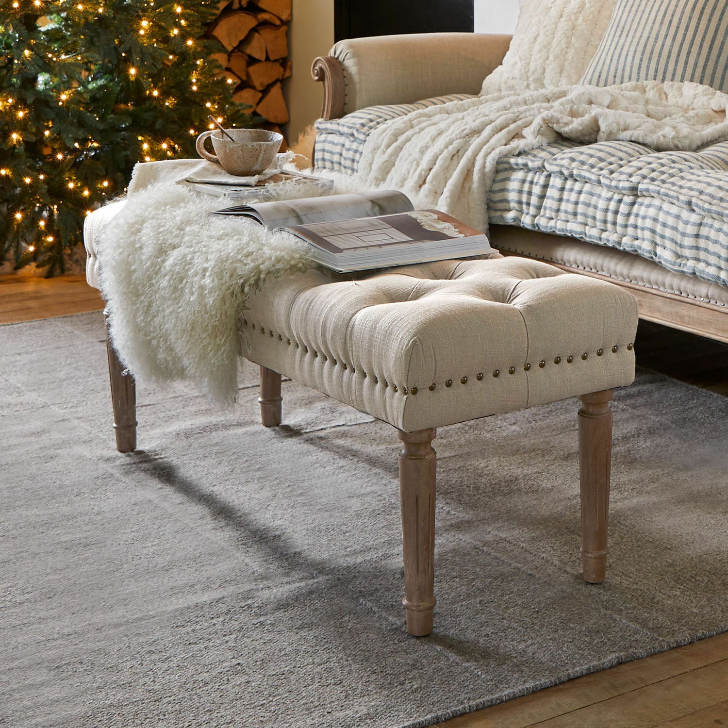 Bank Brookfield Beige gepolsterte Bank mit Holzbeinen auf grauem Teppich in gemütlichem Wohnzimmer mit Weihnachtsbaum.