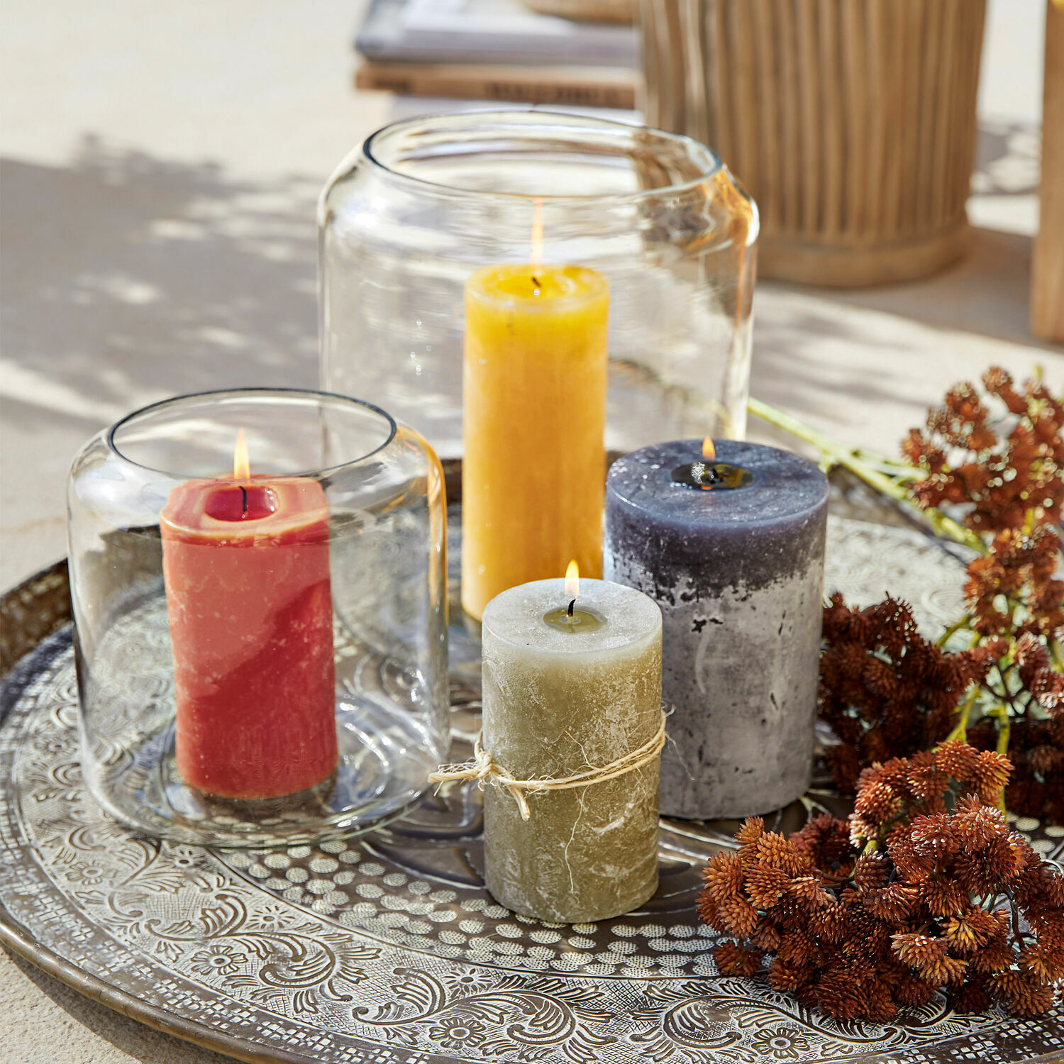 Vier farbige Kerzen auf dekorativem Metalltablett als stilvolle Wohnraumdekoration