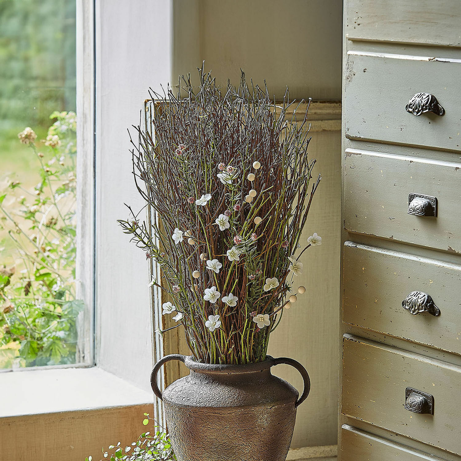 Deko-Blumenstrauss Verilo Dekorative braune Metallvase mit Zweigen und weissen Blüten auf der Fensterbank