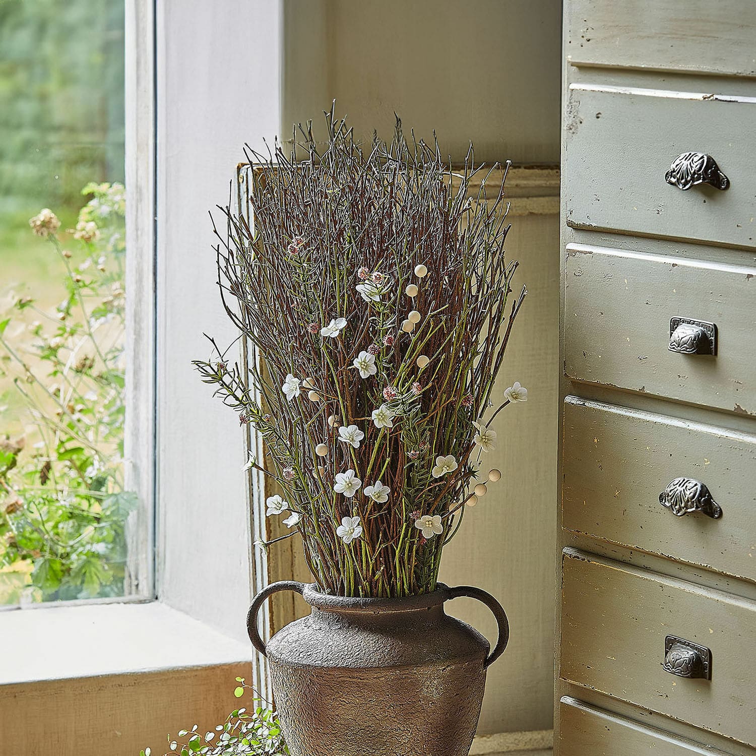 Deko-Blumenstrauss Verilo Dekorative braune Metallvase mit Zweigen und weissen Blüten auf der Fensterbank
