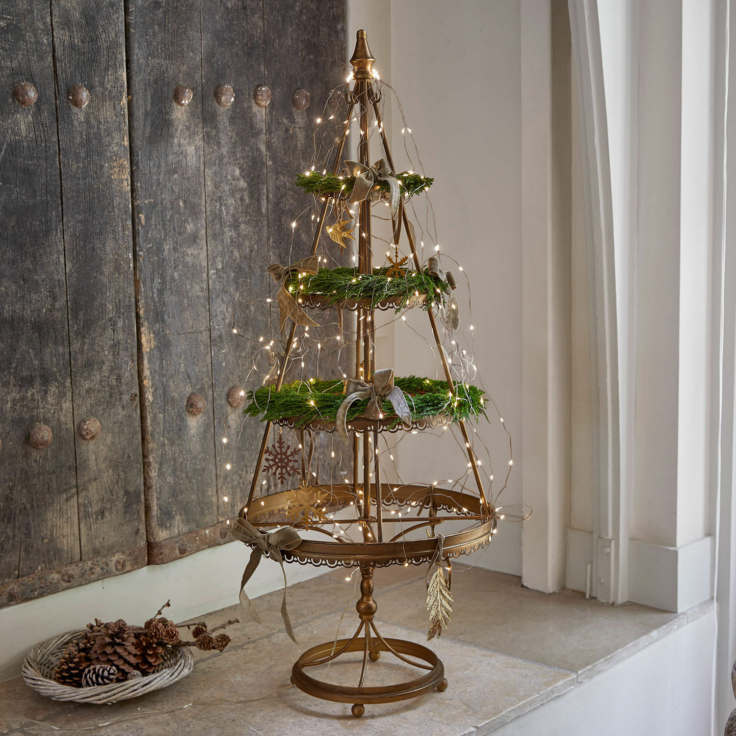 Deko-Baum Yolivine Goldfarbene Metall-Weihnachtsdekoration mit grünen Kränzen und LED-Lichterkette auf dem Tisch