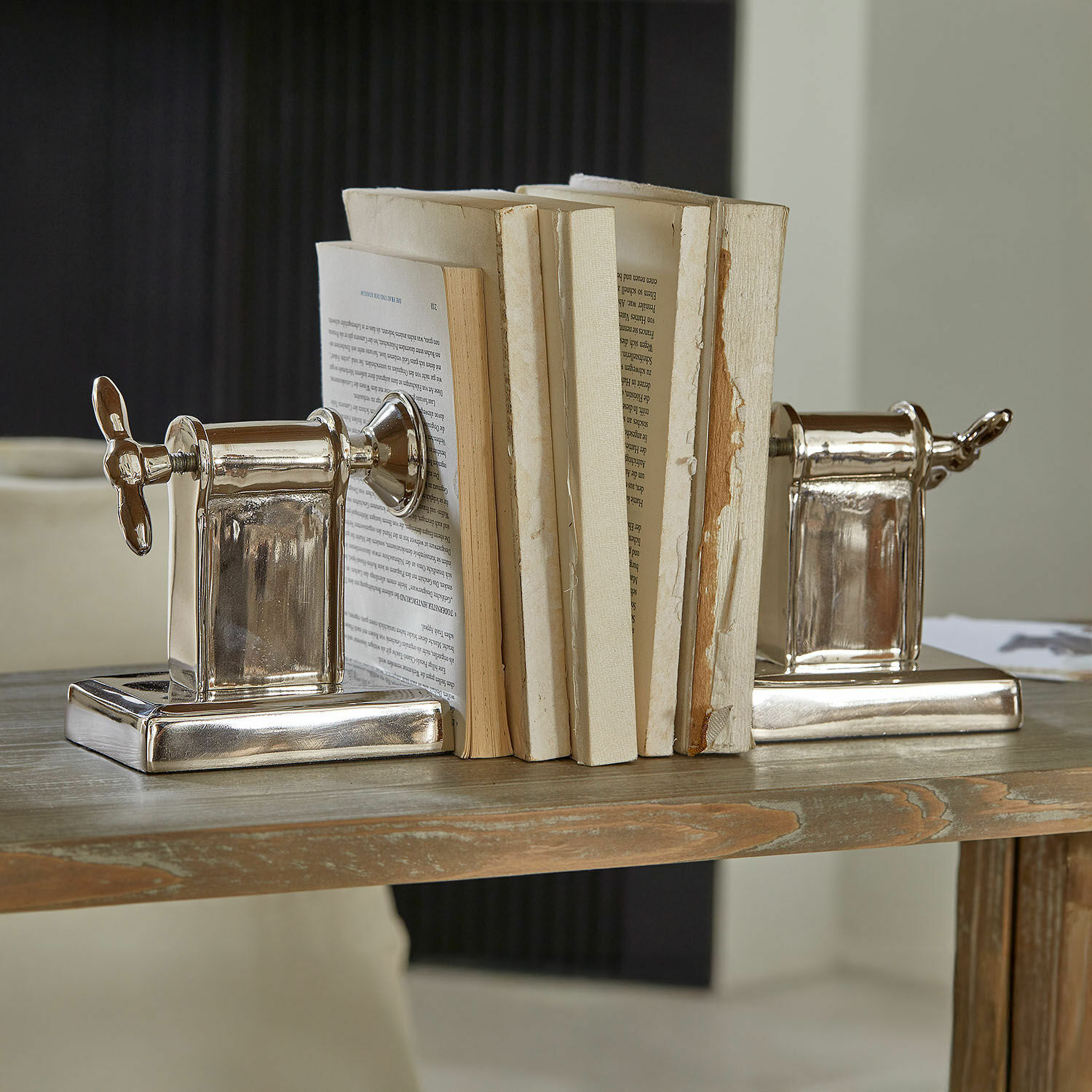 Buchstütze 2er Set Iskora Silberne Buchstützen aus Metall in Schraubenform auf Holztisch, Wohnaccessoire