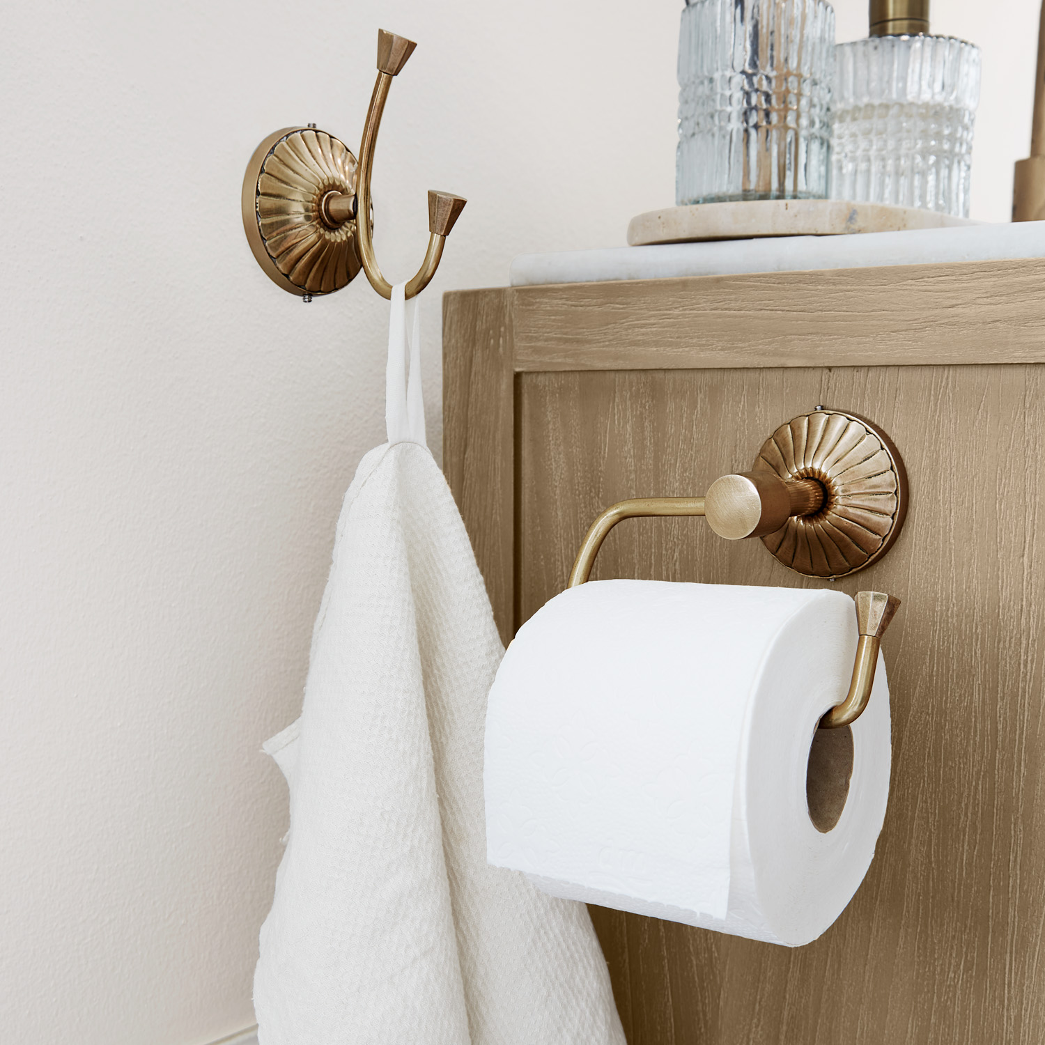 Messing Toilettenpapierhalter und Doppelhaken mit weissem Handtuch im Badezimmer