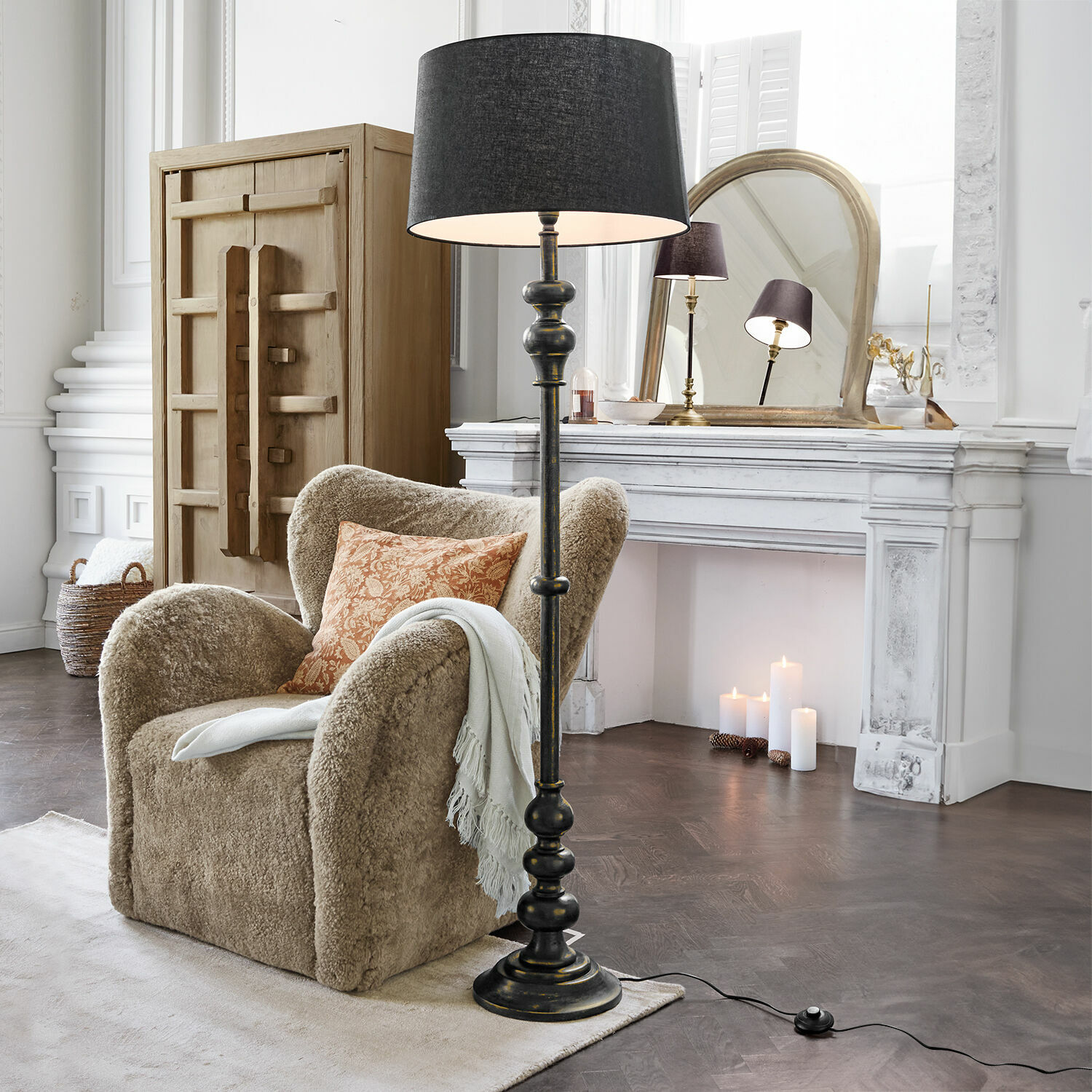 Stehlampe Reville Schwarze Stehlampe mit Lampenschirm im klassischen Wohnzimmer mit beigem Sessel und weissem Kamin