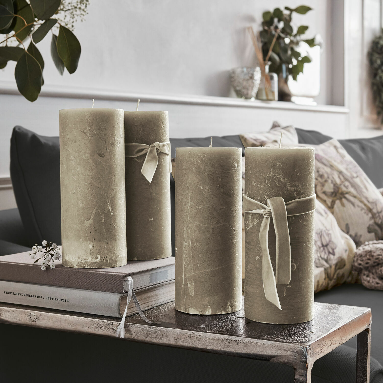 Kerze 4er Set Homel Vier beige dekorative Kerzen mit Bändern auf einem Metalltisch im Wohnzimmer