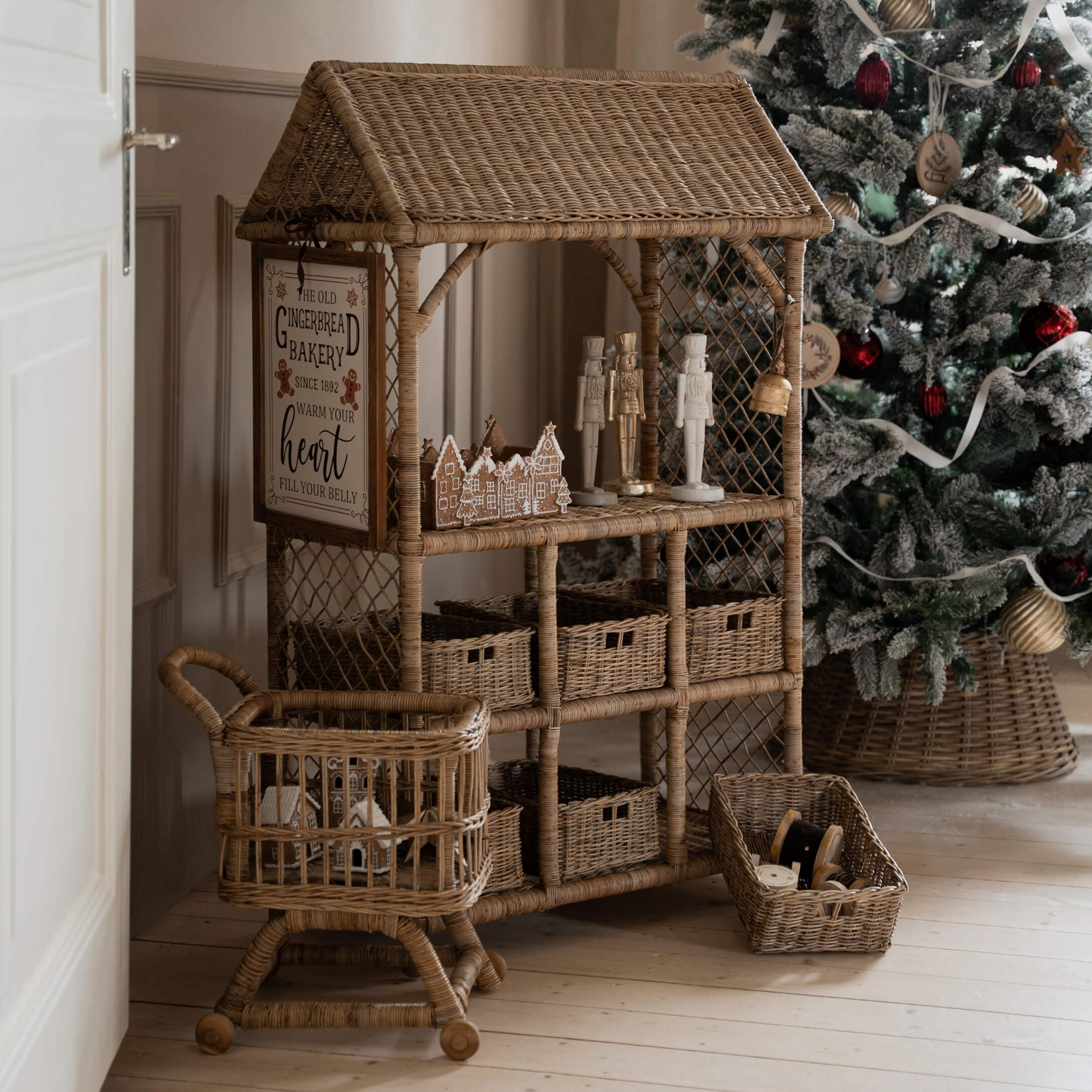 Natürlicher Rattanmöbel mit Weihnachtsdekorationen und geschmücktem Baum im Hintergrund