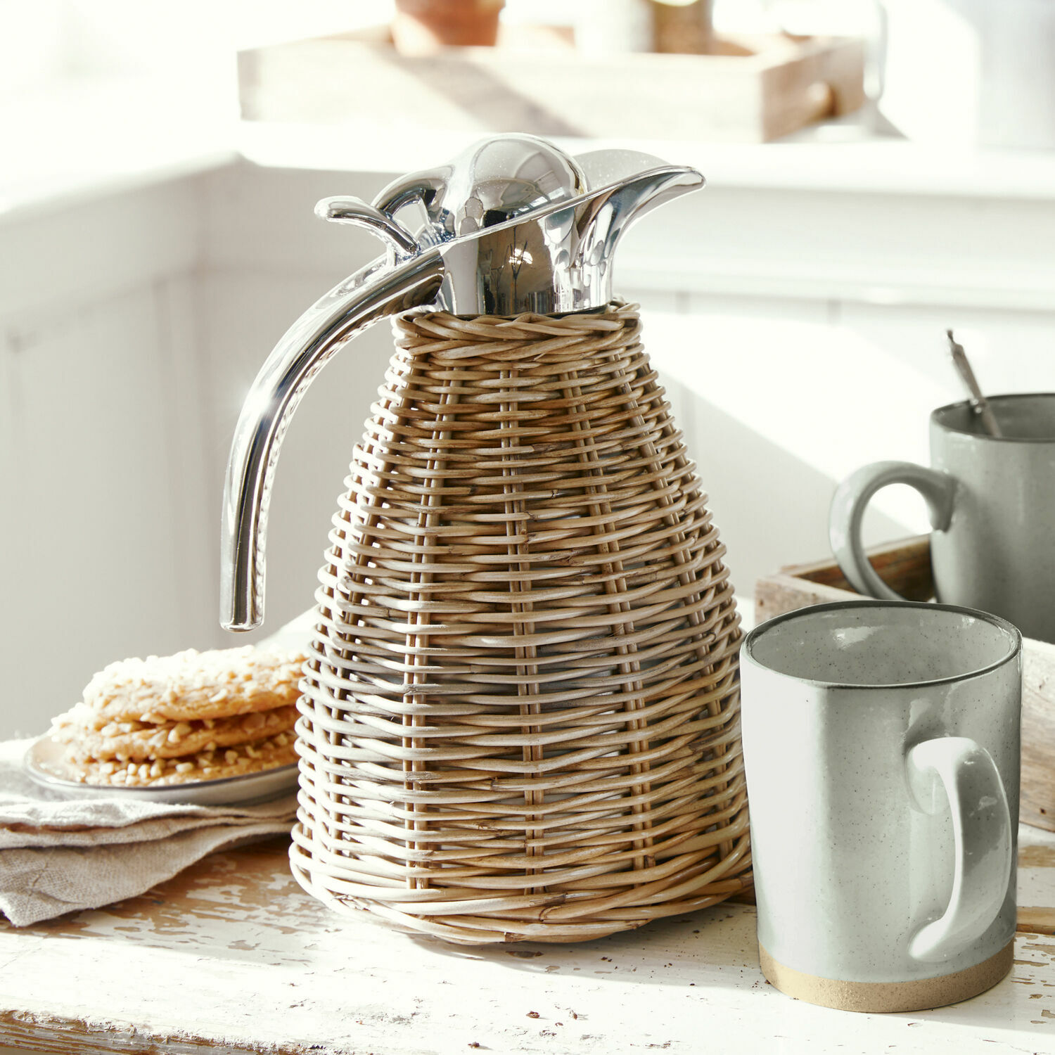 Thermoskanne Senta Thermoskanne aus Rattan mit Metallverschluss und Griff auf rustikalem Holztisch