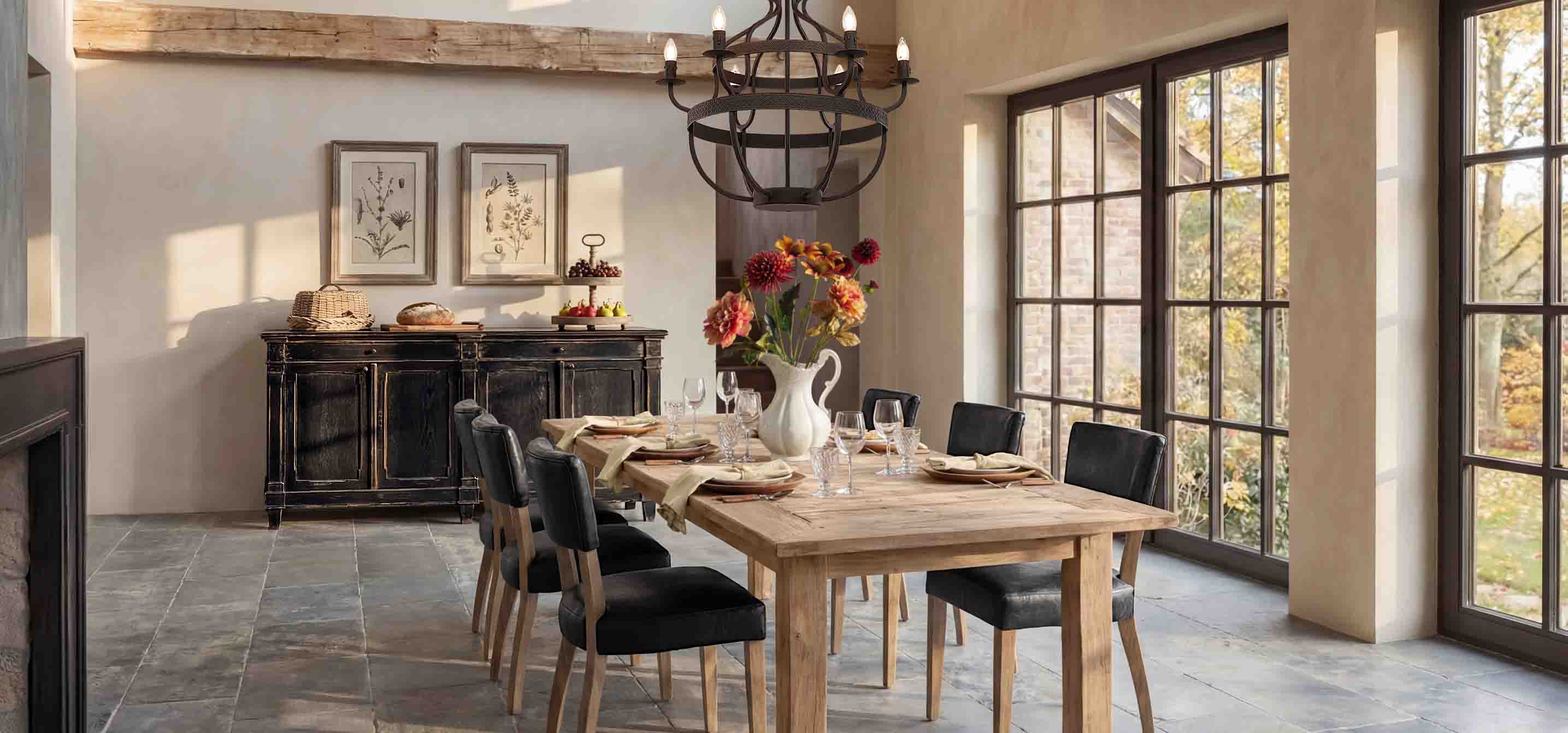 Esszimmer mit Holztisch, schwarzen Stühlen und rustikalem Sideboard vor großen Fenstern
