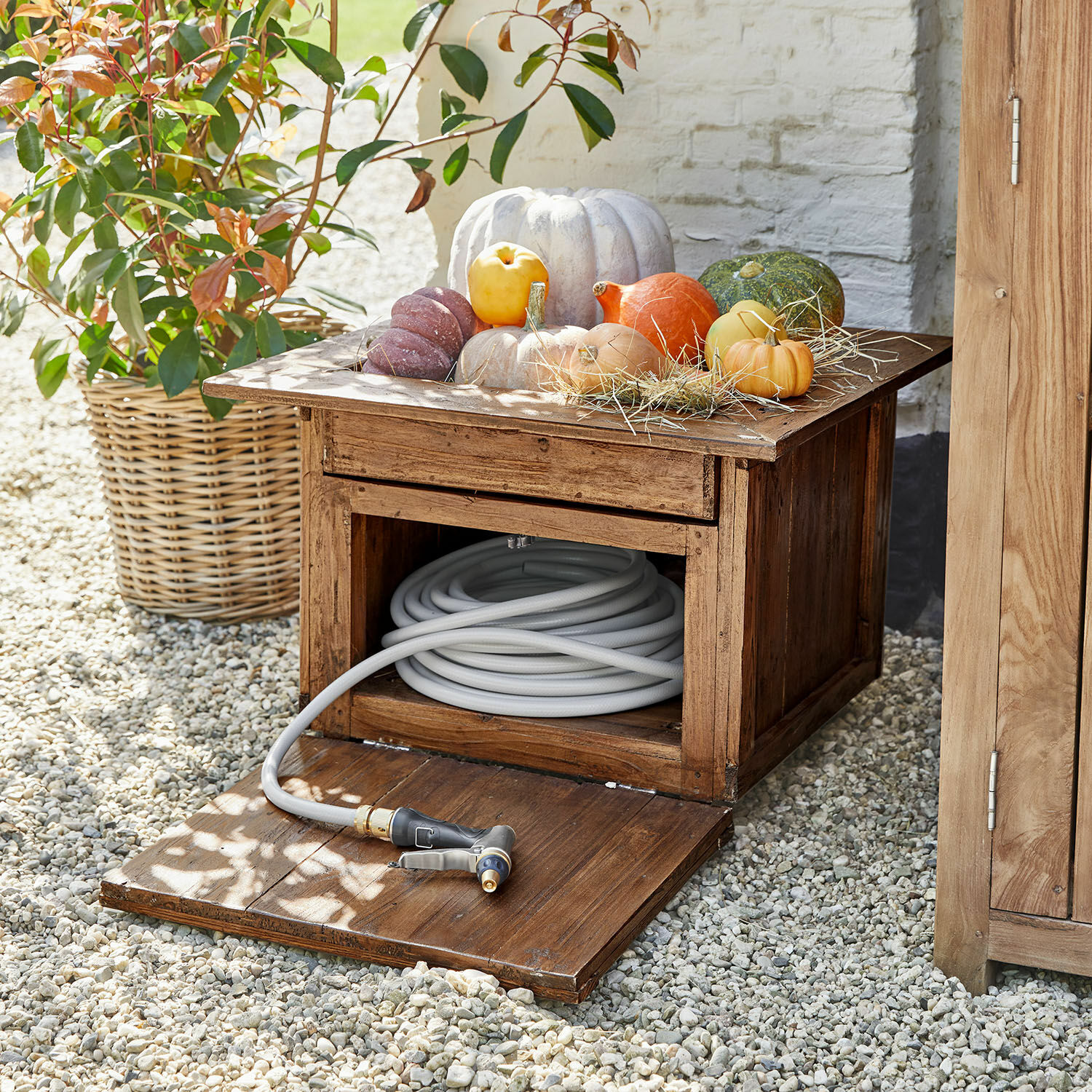 Gartenschlauchtopf Fontabre Holz-Gartenschrank mit grauem Gartenschlauch und dekorativen Kürbissen obenauf