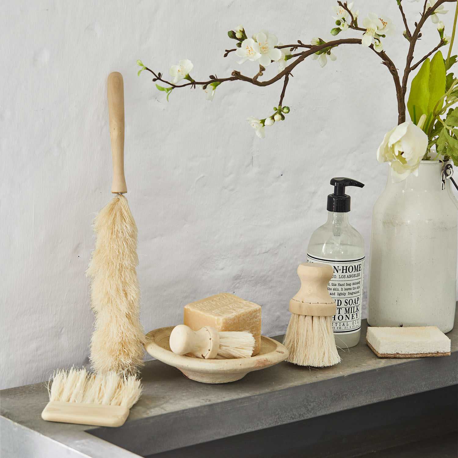 Deko-Bürsten 4er Set Jalexor Set aus natürlichen Reinigungsbürsten mit Holzgriffen und Seife auf grauem Regal im Badezimmer