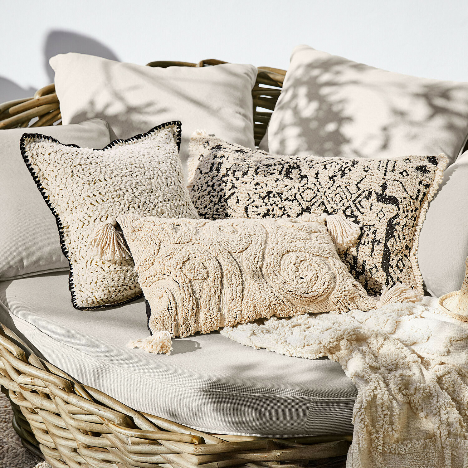 Kissenhülle 3er Set Norlinn Set aus cremefarbenen Dekokissen aus weichem Material auf Rattansofa, Boho-Stil