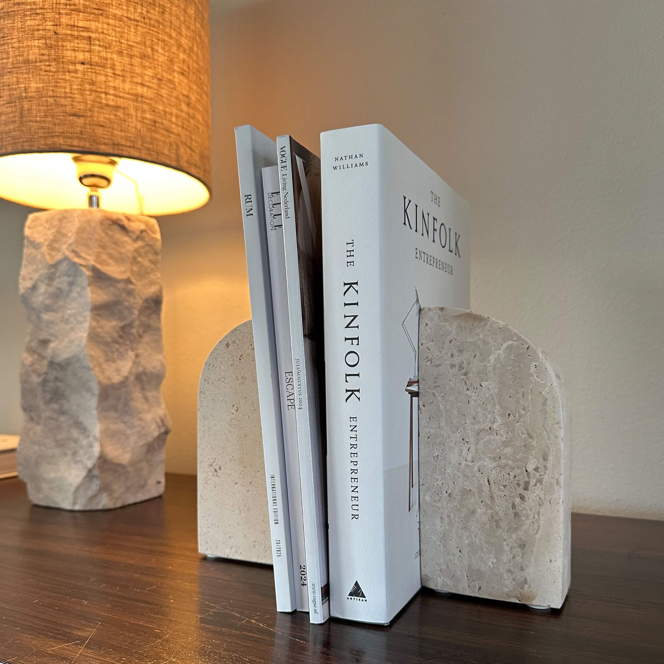 Beige Steinbuchstützen auf Holztisch mit beleuchtetem Lampenhintergrund