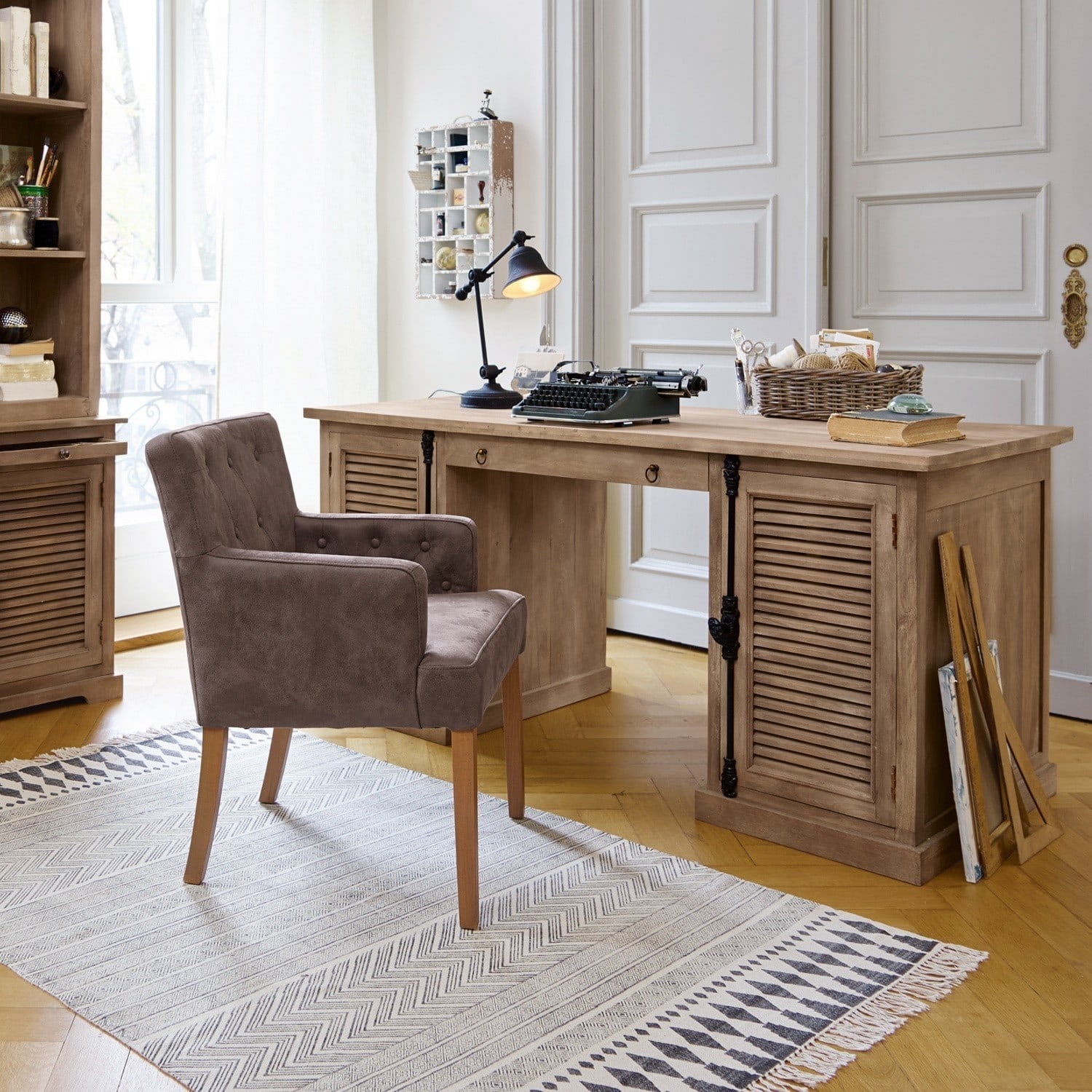 Schreibtisch Woodmore Holzschreibtisch mit Schubladen und braunem Polstersessel auf hellem Teppich in hellem Raum