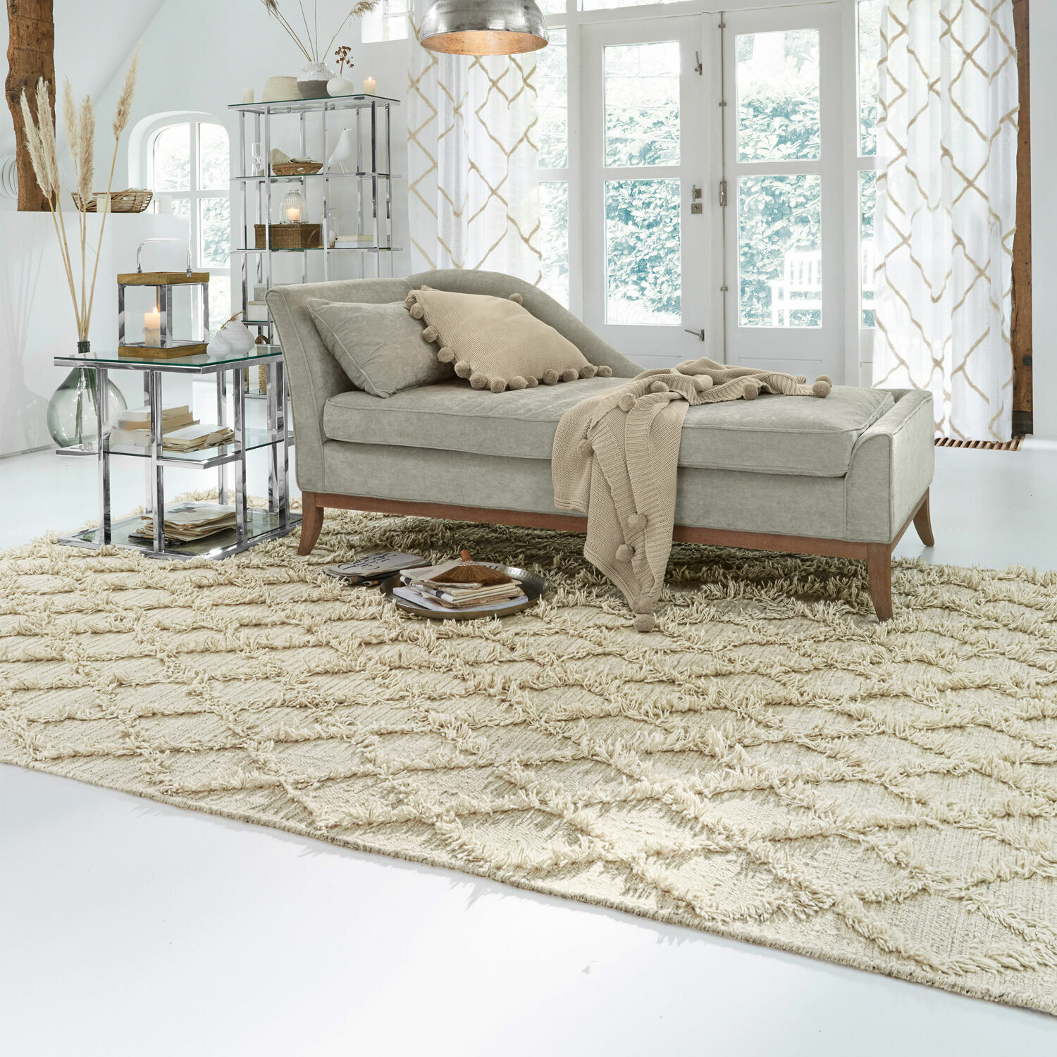 Chaiselongue mit grauem Bezug und Holzbeinen auf beigem Teppich in hellem Wohnzimmer