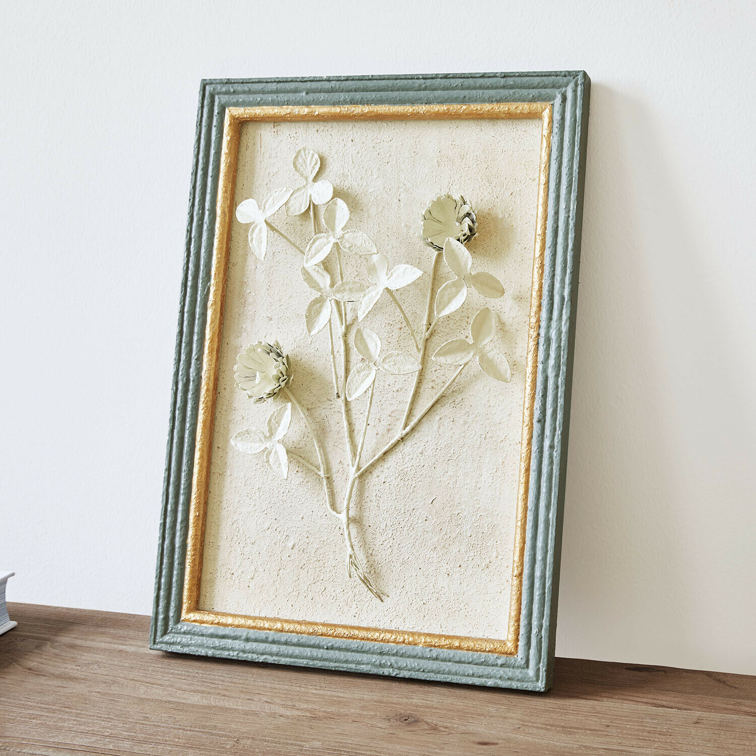 Bild Rivolenne Dekoratives Bild mit Blumenrelief in grün-goldenem Rahmen auf Holztisch stehend