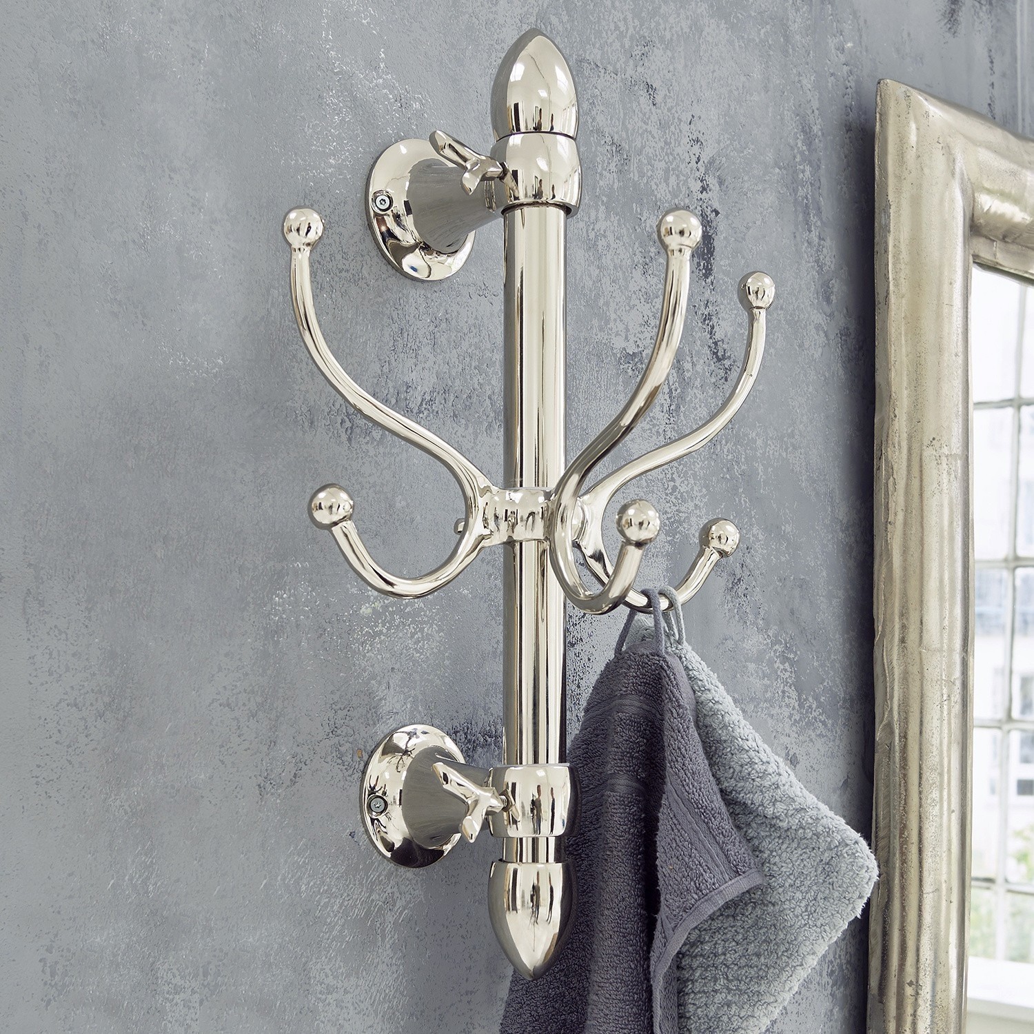 Haken Anthé Wandhaken aus verchromtem Metall mit Haken, an denen graue Handtücher im Badezimmer hängen.