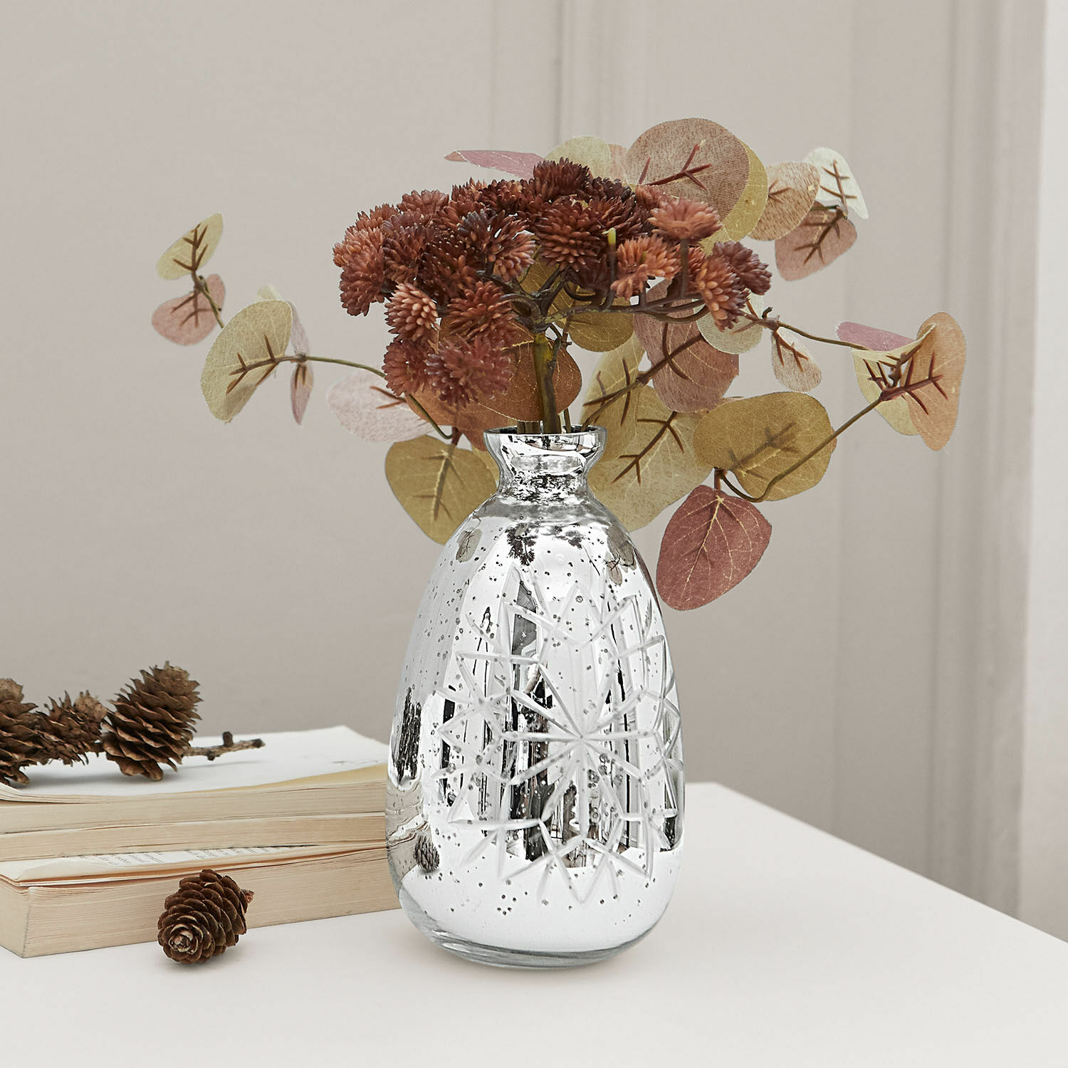Vase Zorelie Silberne Glasvase mit graviertem Muster und getrockneten braunen Blumen auf weissem Tisch