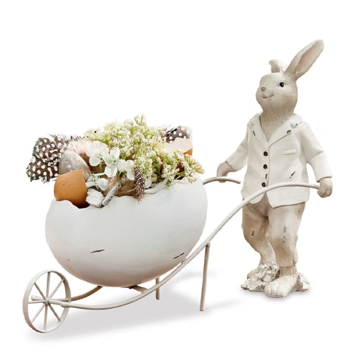 Dekorativer weisser Hase mit Blumentopf in Eierschalenform, gefüllt mit Blumen und Federn, Frühlingsdekoration