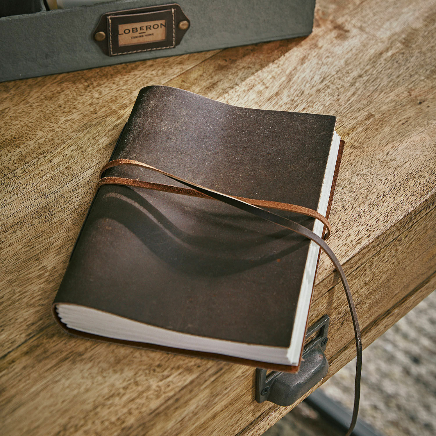 Notizbuch Rédené Braunes Ledernotizbuch mit Riemen auf Holztisch, praktisches Schreib- und Notizaccessoire