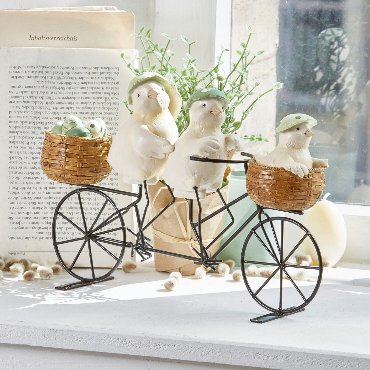Küken Family Tour Dekoration mit drei weissen Vögeln mit grünen Hüten auf Metallvelo mit Korb aus Weide