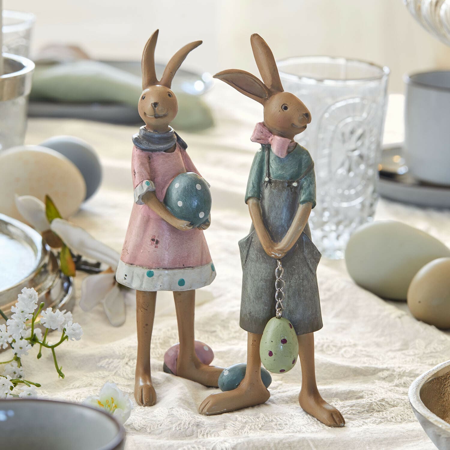 Hase 2er Set Sivalex Zwei dekorative Hasenfiguren aus Metall in Pastellfarben mit Ostereiern auf einem Tisch