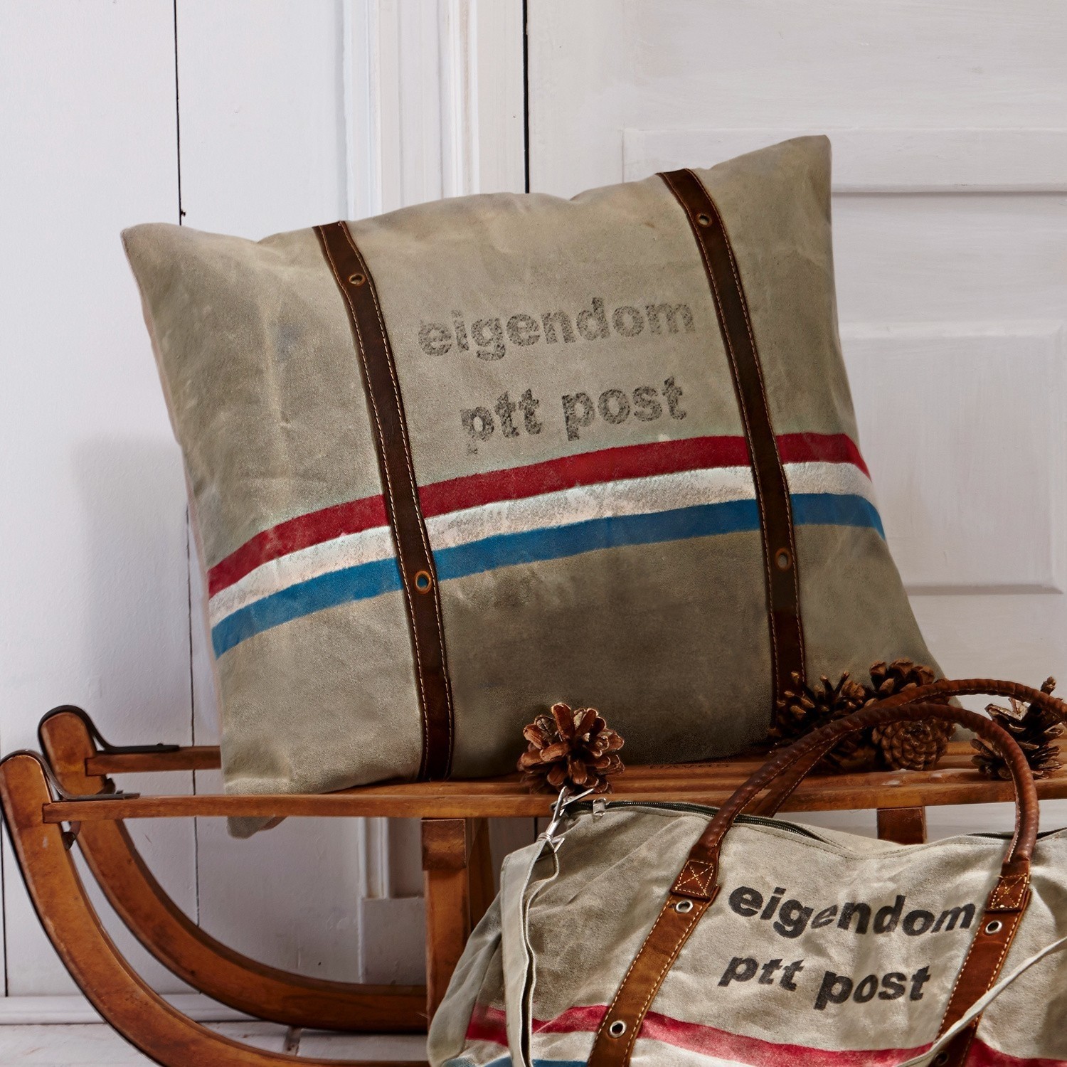 Beiges Kissen und Tasche aus Stoff mit braunen Riemen und rot-blauem Streifenmuster, Wohnaccessoire
