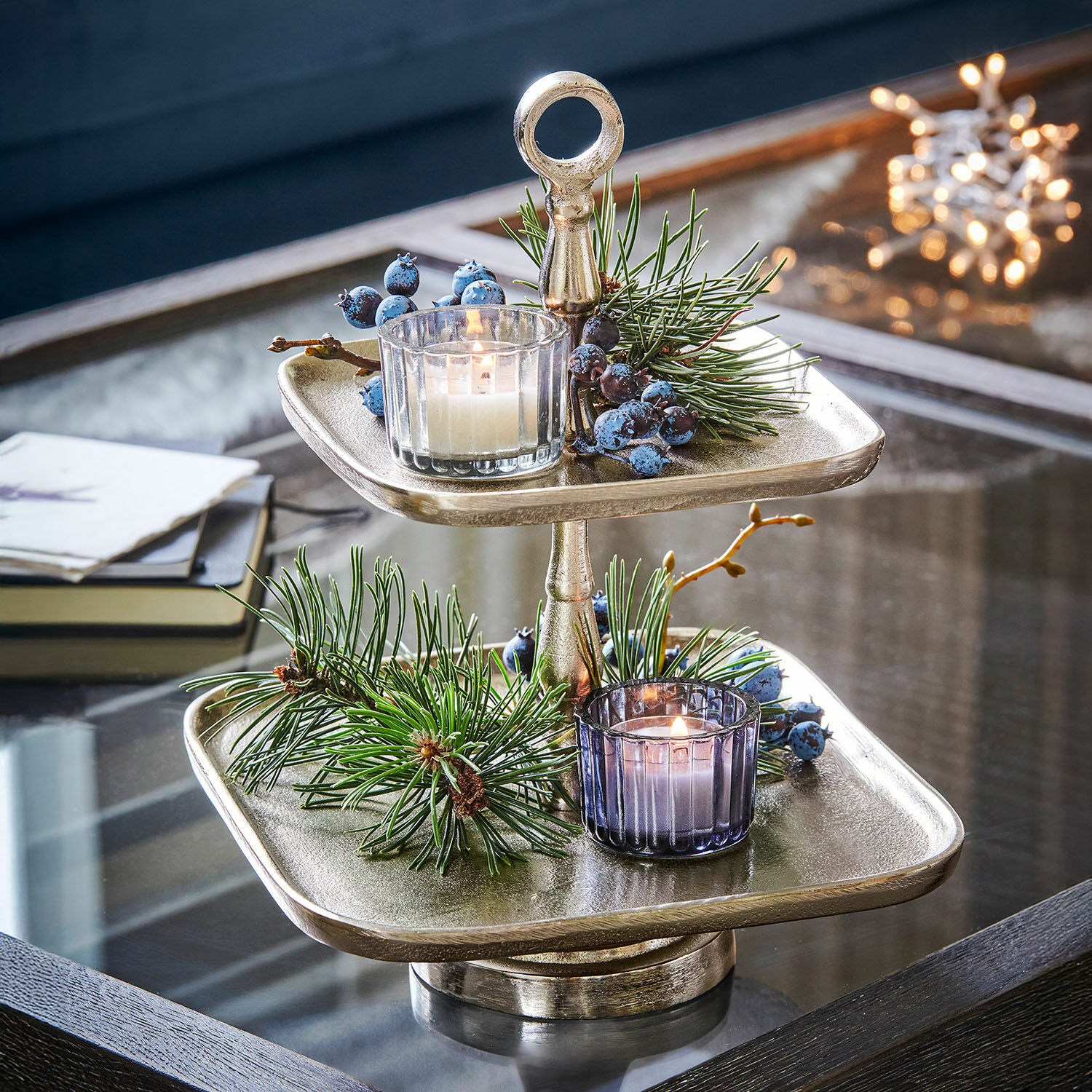 Etagere Tuarla Zweistufige silberne Metall-Etagere mit Weihnachtsdekoration und Kerzen auf Glastisch