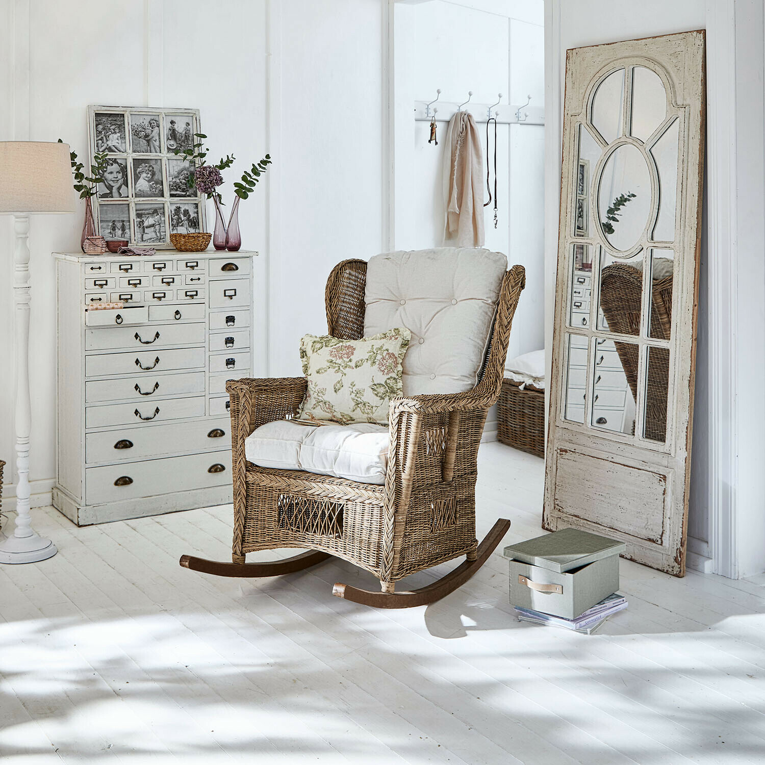 Schaukelstuhl Jeveren Rattanschaukelstuhl mit cremefarbenen Polstern in hellem Zimmer mit weissem Holzboden