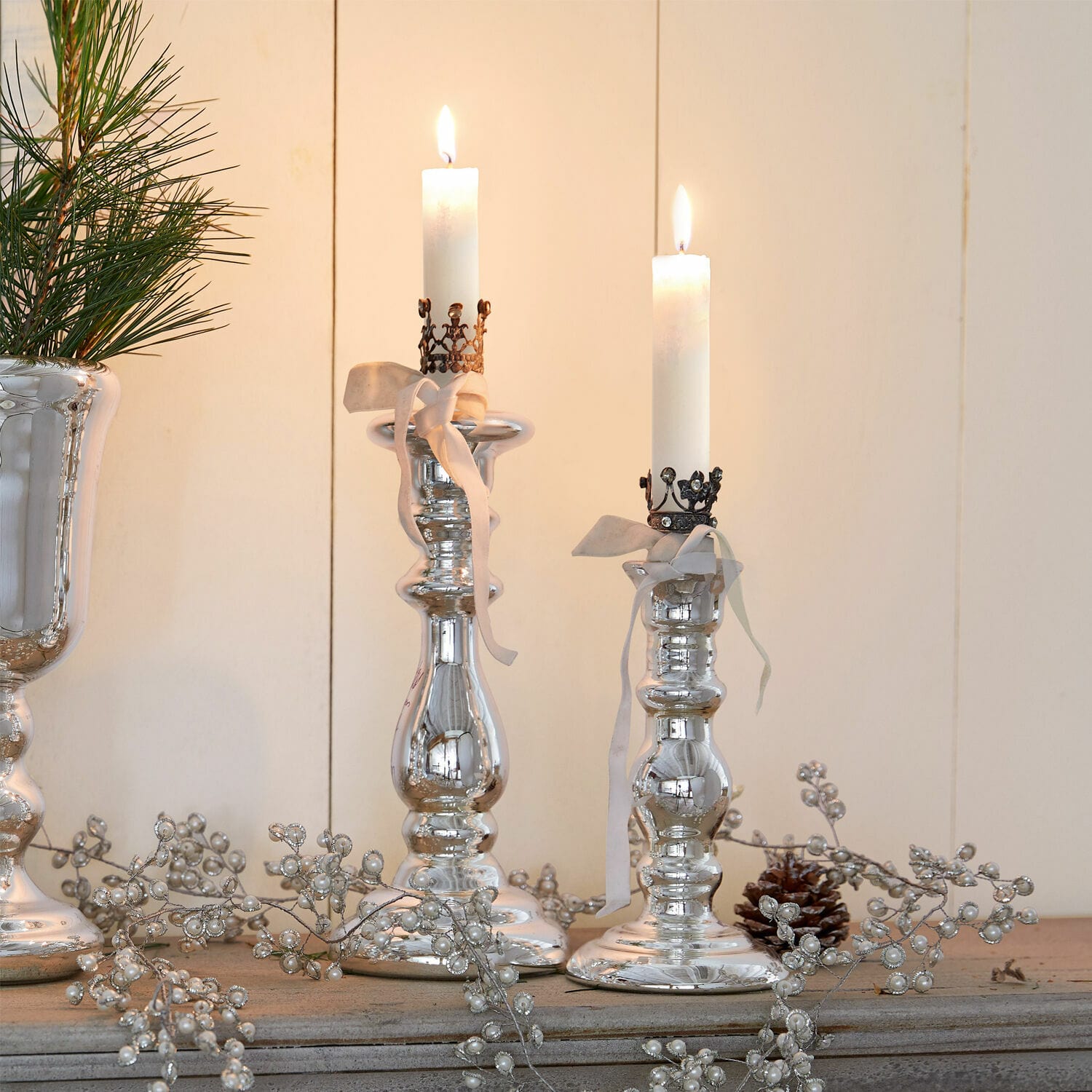 Kerzenständer 2er Set Gao Silberne Kerzenhalter mit weissen Kerzen und dekorativen Bändern auf rustikalem Holzuntergrund