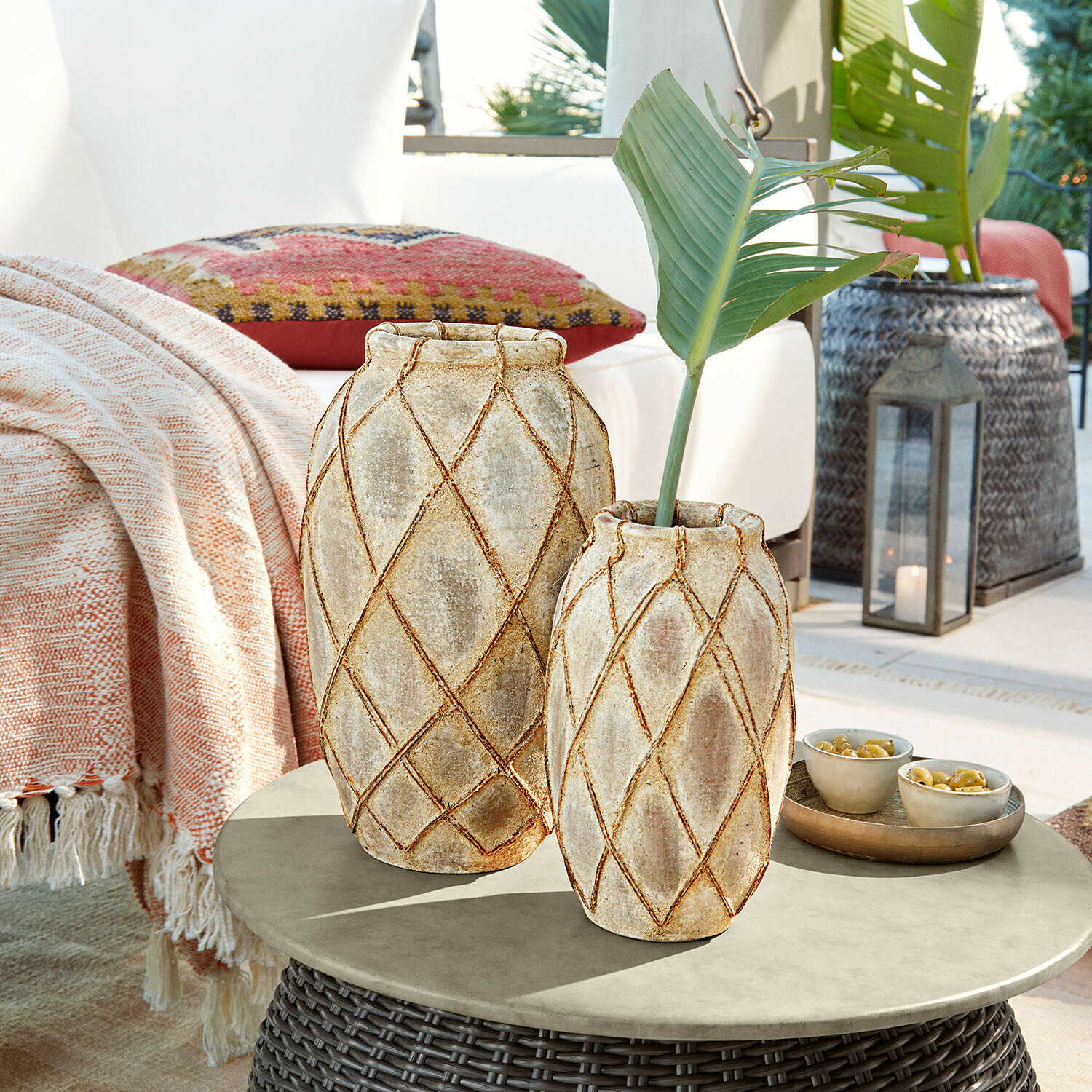 Vase 2er Set Deloriva Zwei beige Keramikvasen mit geometrischem Muster auf einem Rattantisch im Aussenbereich