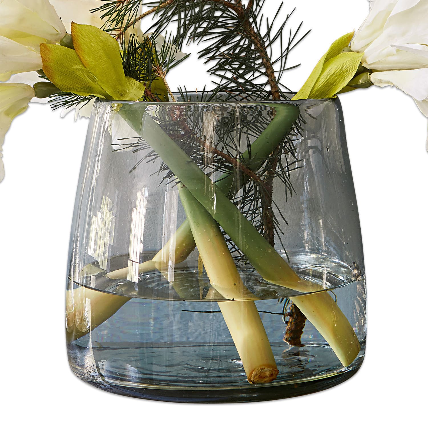 Vase Inga Transparente Glasvase mit Wasser, grünen Stielen und weissen dekorativen Blumen