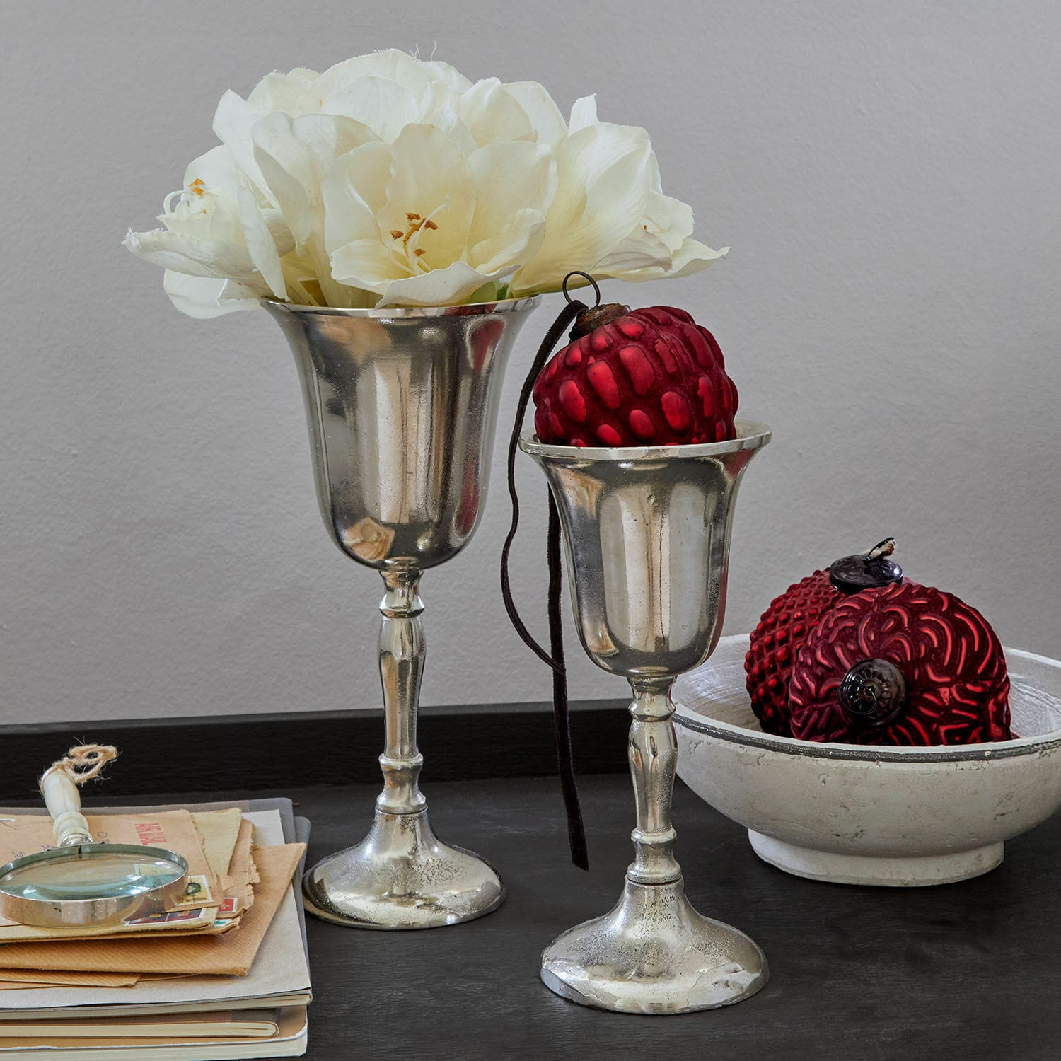 Vase 2er Set Solérie Zwei silberne Dekokelche mit weissen Blumen und roten Ornamenten auf schwarzem Tisch