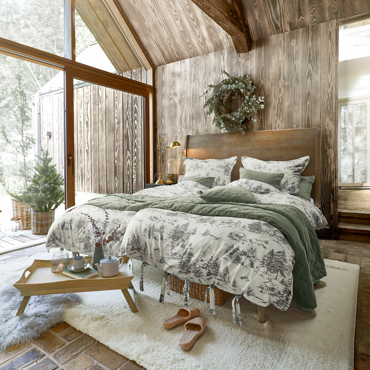Bettwäsche Héroux Gemütliches Schlafzimmer mit Holzwand und Bett mit grün-grauer Bettwäsche im Waldmuster