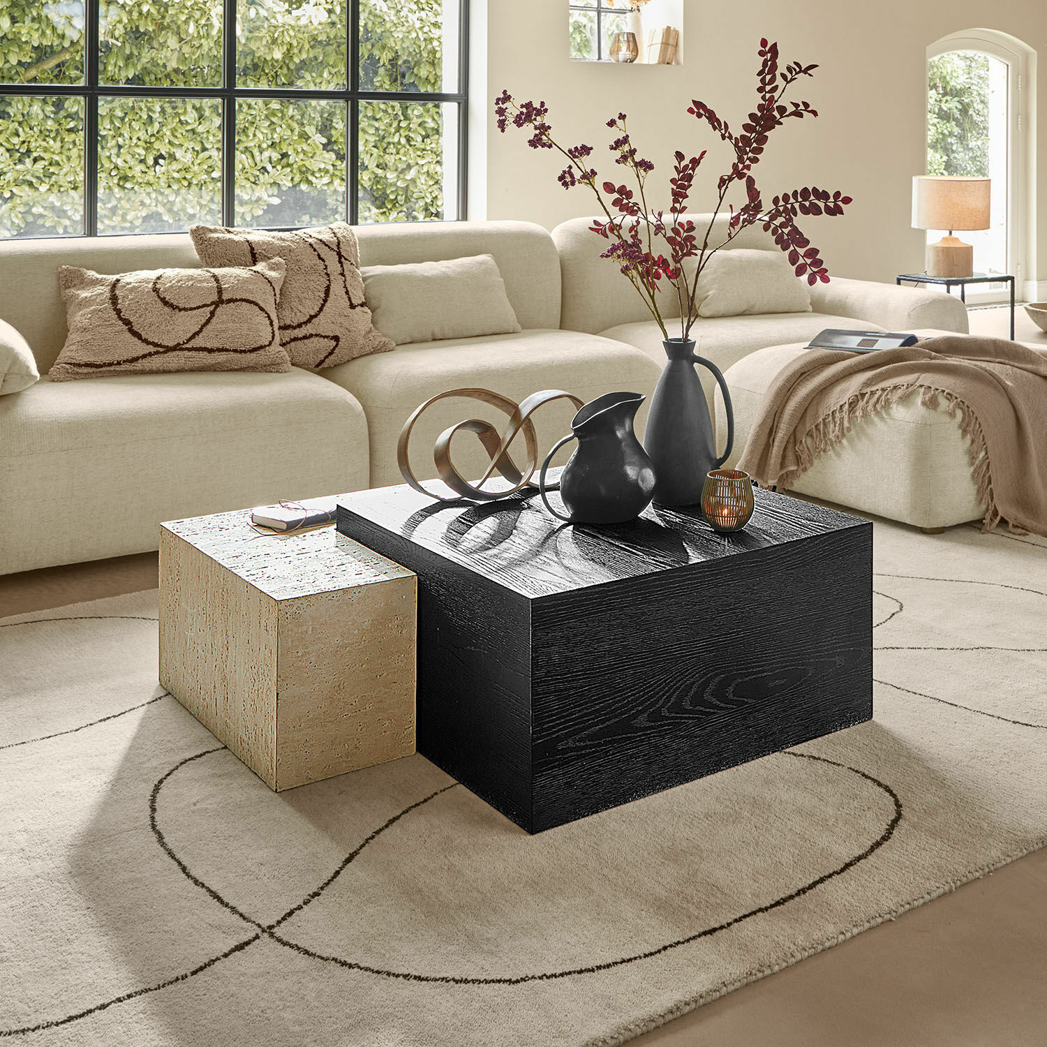 Couchtisch 2er Set Caleneuve Moderner Wohnraum mit beigem Sofa und zwei Couchtischen aus Holz und Stein, Dekorationen darauf